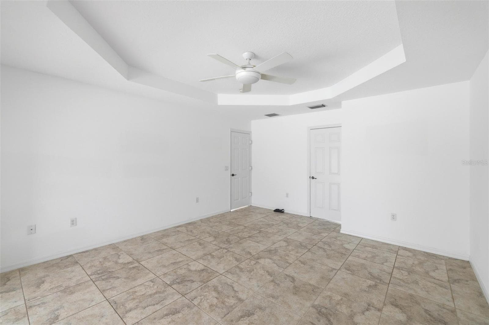 Spacious primary suite with tile floors, ceiling fan, and lots of natural light - 605 ROTONDA CIR, ROTONDA WEST