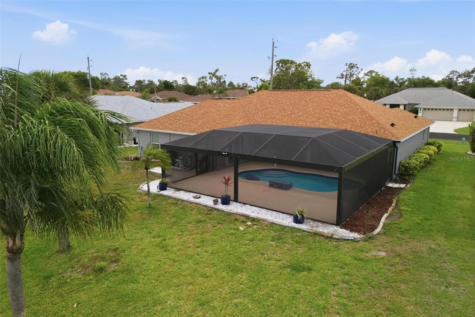 Bird's-eye view showcasing home layout, newly redone pool, and landscaped grounds - 605 ROTONDA CIR, ROTONDA WEST