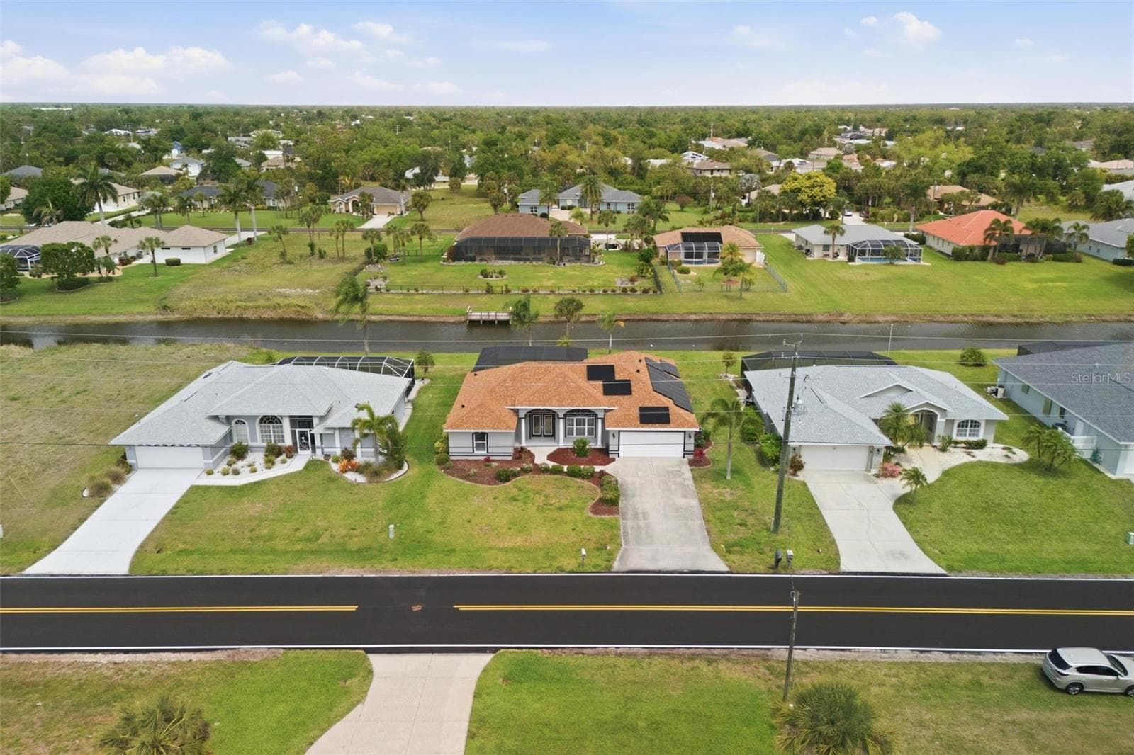 Aerial shot highlighting home's footprint, pool, and peaceful canal-side setting - 605 ROTONDA CIR, ROTONDA WEST
