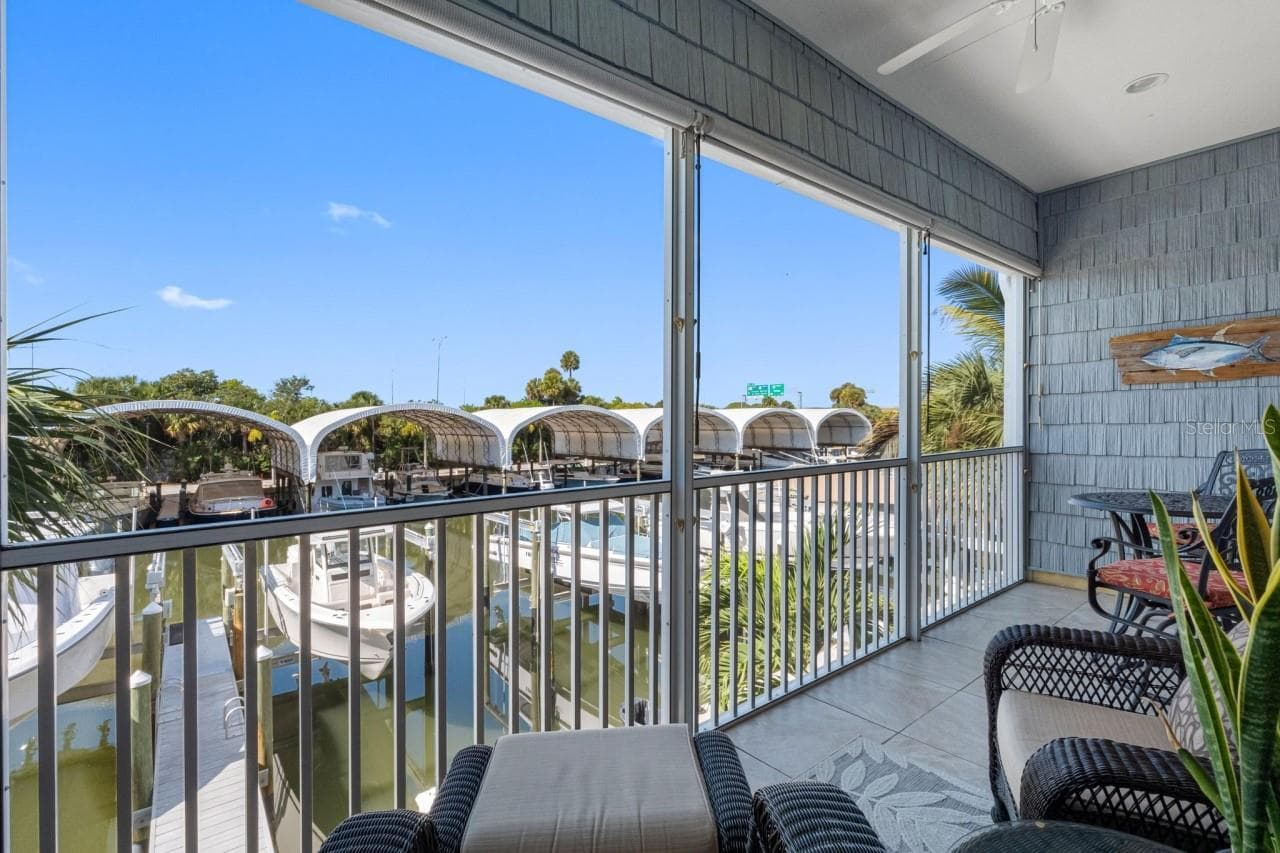 Balcony with a mounted TV and water views. Enjoy your morning coffee while gazing out at what could be your own ?? boat sitting there waiting for you. - 6057 MOORINGS DR S, ST PETERSBURG