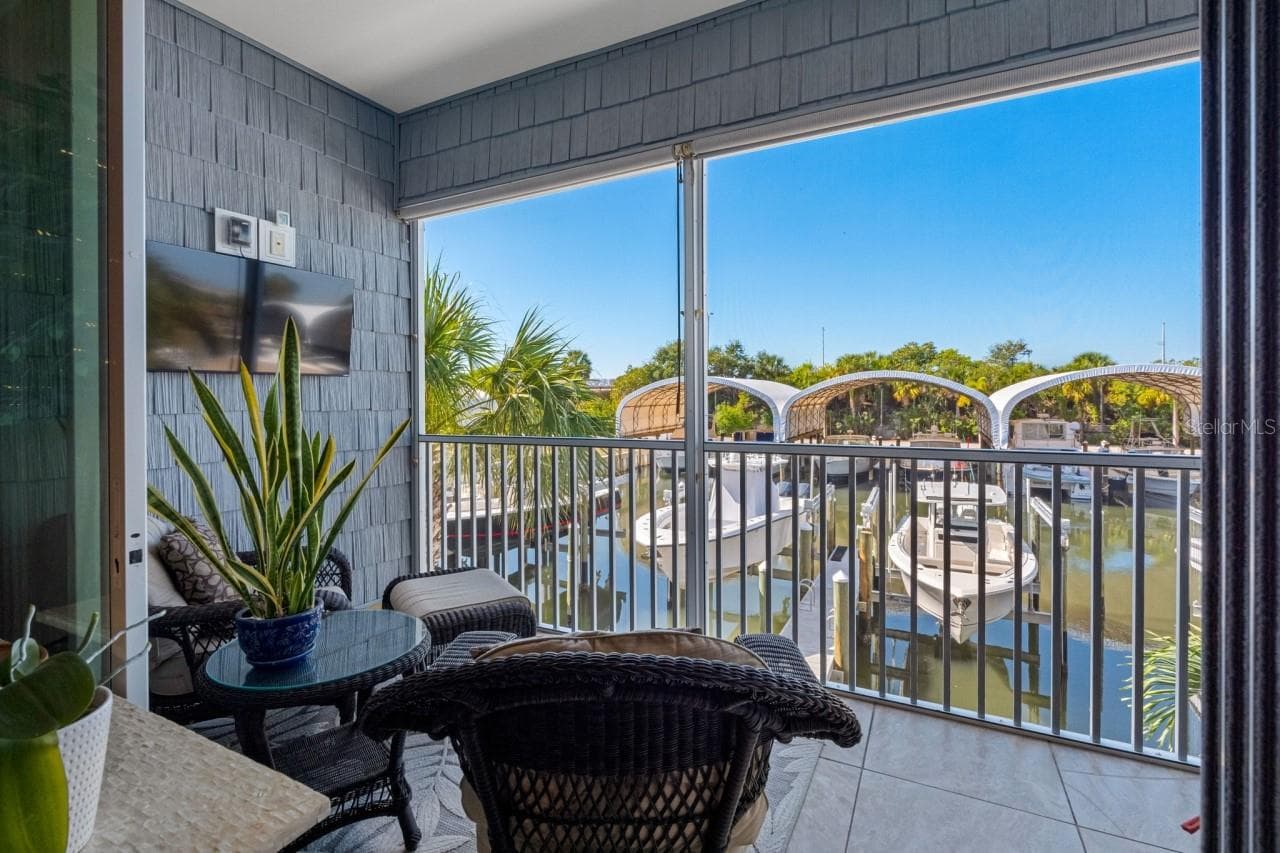 Balcony with a mounted TV and water views. Enjoy your morning coffee while gazing out at what could be your own ?? boat sitting there waiting for you. - 6057 MOORINGS DR S, ST PETERSBURG