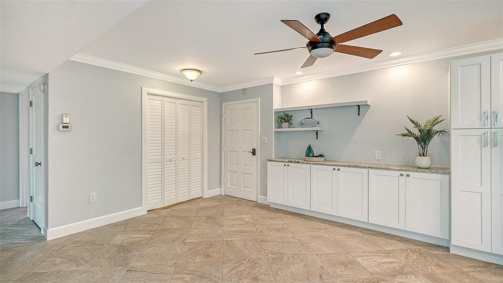 The cabinetry and granite extend into the entire length of the dining area, creating additional storage and an elegant serving space. - 225 HOURGLASS WAY #106, SARASOTA