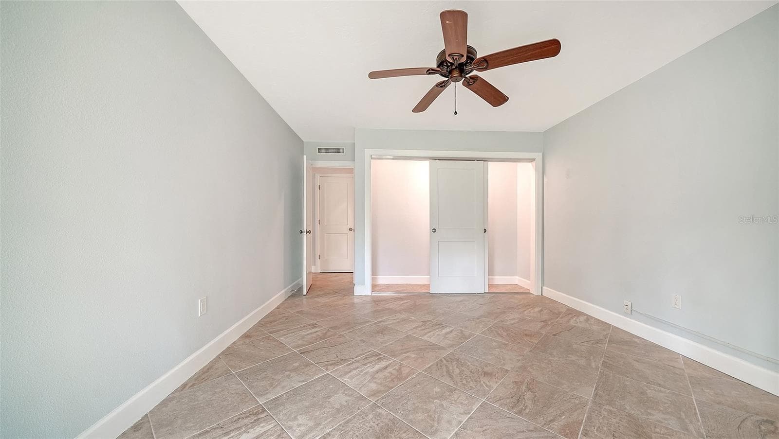 Guest bedroom with a wall of built-in closet. - 225 HOURGLASS WAY #106, SARASOTA