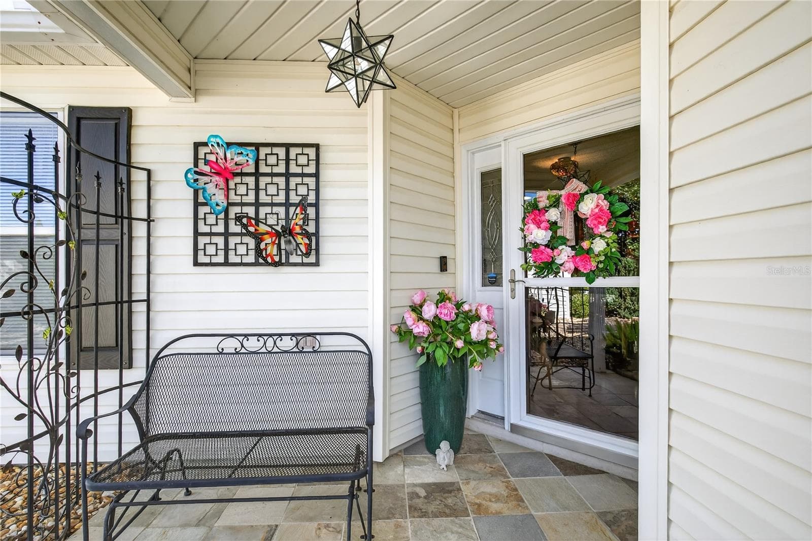 The welcoming front entrance is beautifully enhanced with a durable slate tile floor, complemented by a functional glass storm door that allows for ample natural light, and finished off with a touch of elegance through the inclusion of an updated, stylish glass star light fixture. - 1147 ELIZABETH CT, THE VILLAGES