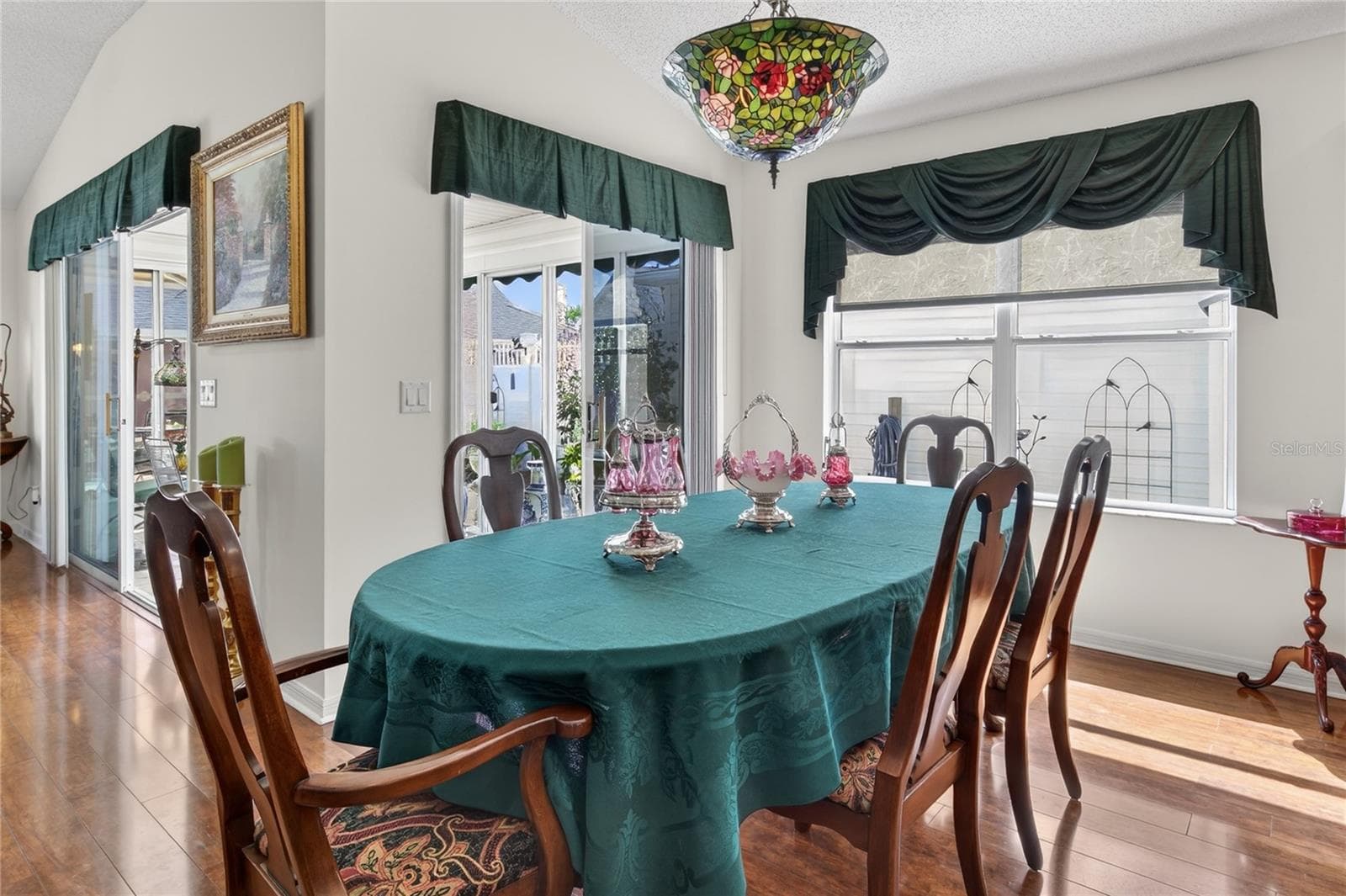 The Dining Room and Living Room both feature elegant glass sliders, providing seamless access to the inviting and comfortable enclosed lanai, enhancing the indoor-outdoor living experience. - 1147 ELIZABETH CT, THE VILLAGES