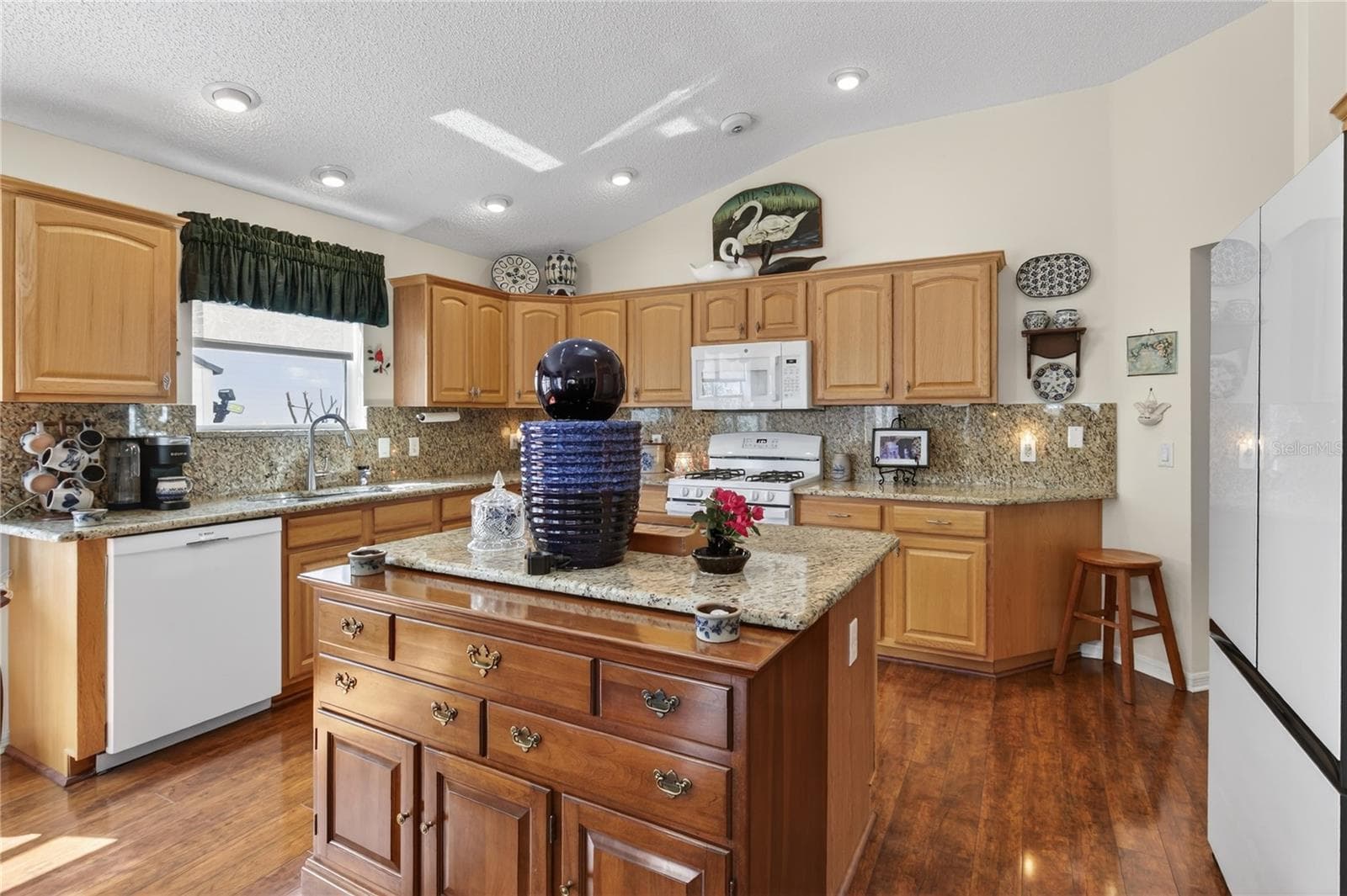This captivating kitchen is a true chef's paradise, boasting beautifully crafted warm wood cabinets, complemented by stunning, durable granite countertops that provide both an exquisite aesthetic and a practical workspace for culinary creations. S - 1147 ELIZABETH CT, THE VILLAGES