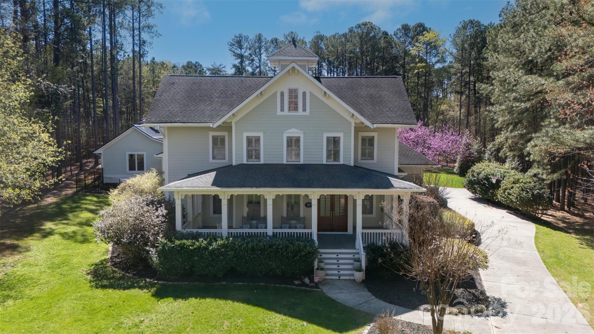 Charming and welcoming porch wraps around the front. - Mooresville