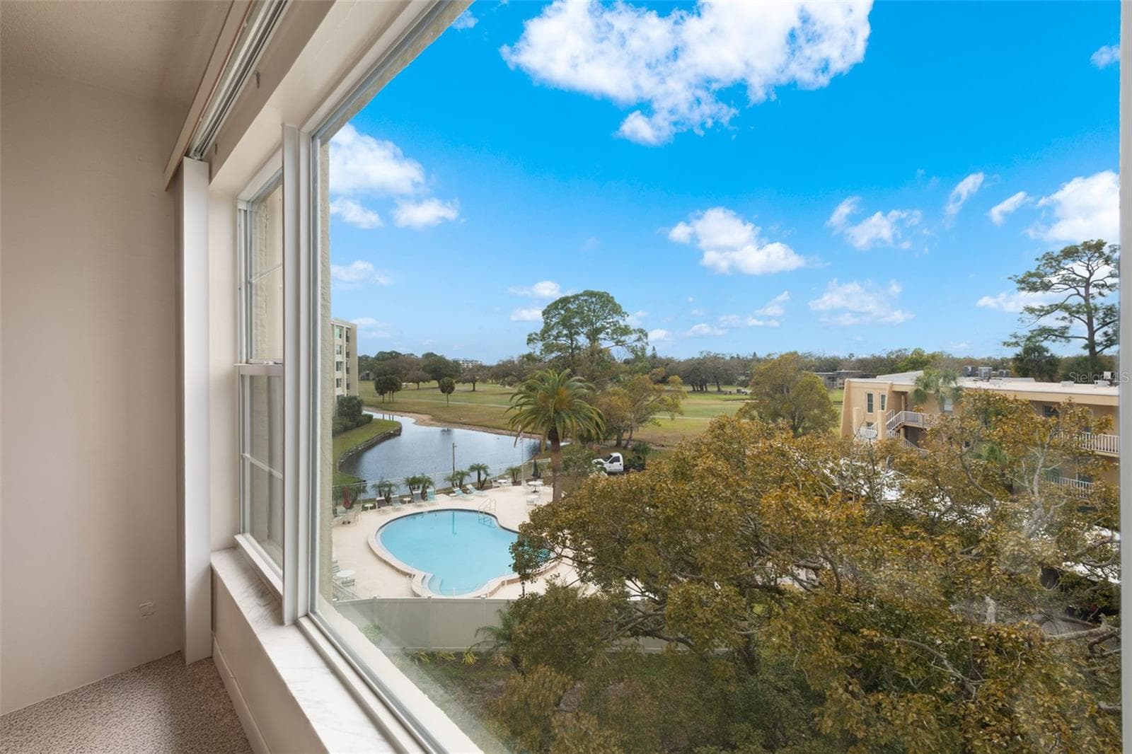 View of pool and golf course from the large living room window - 225 COUNTRY CLUB DR #F-1401, LARGO