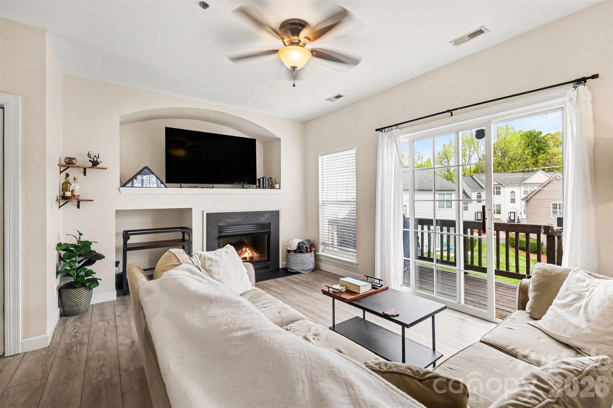 The inviting living space features a thoughtfully designed layout with a spacious cut-out alcove perfect for a large television, complemented by a cozy fireplace that creates a warm focal point for relaxing evenings at home. - 2729 Avalon Loop Road, Charlotte