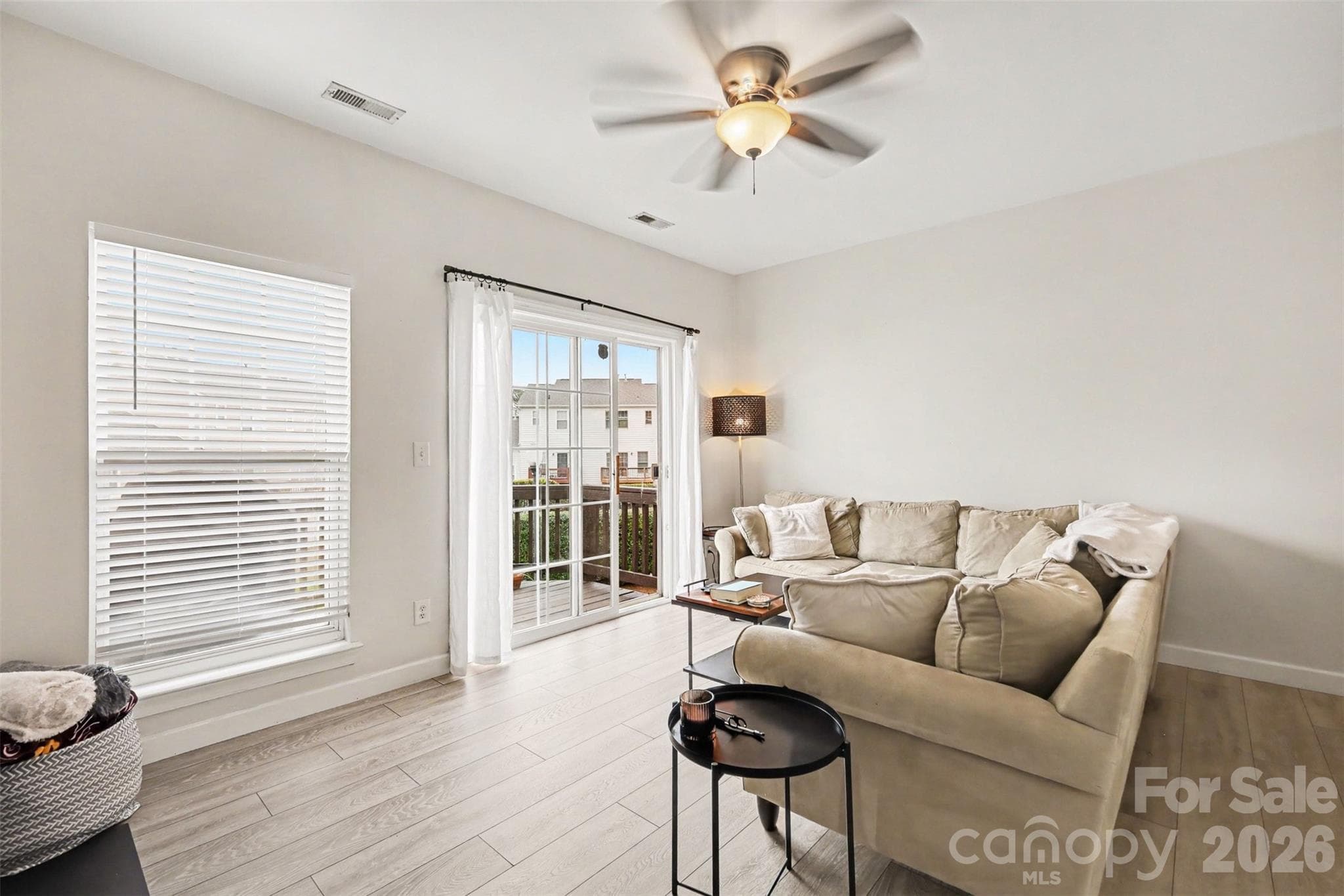 Expansive windows and balcony doors invite natural light into the living area while seamlessly connecting the indoor and outdoor spaces. - 2729 Avalon Loop Road, Charlotte