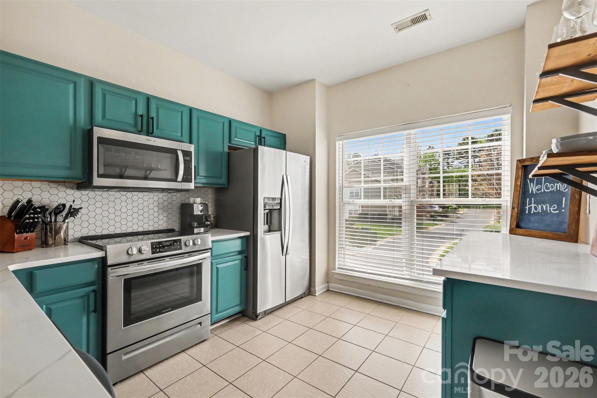 Updated kitchen featuring modern finishes, abundant natural light from large windows, and an inviting open-concept living space. - 2729 Avalon Loop Road, Charlotte