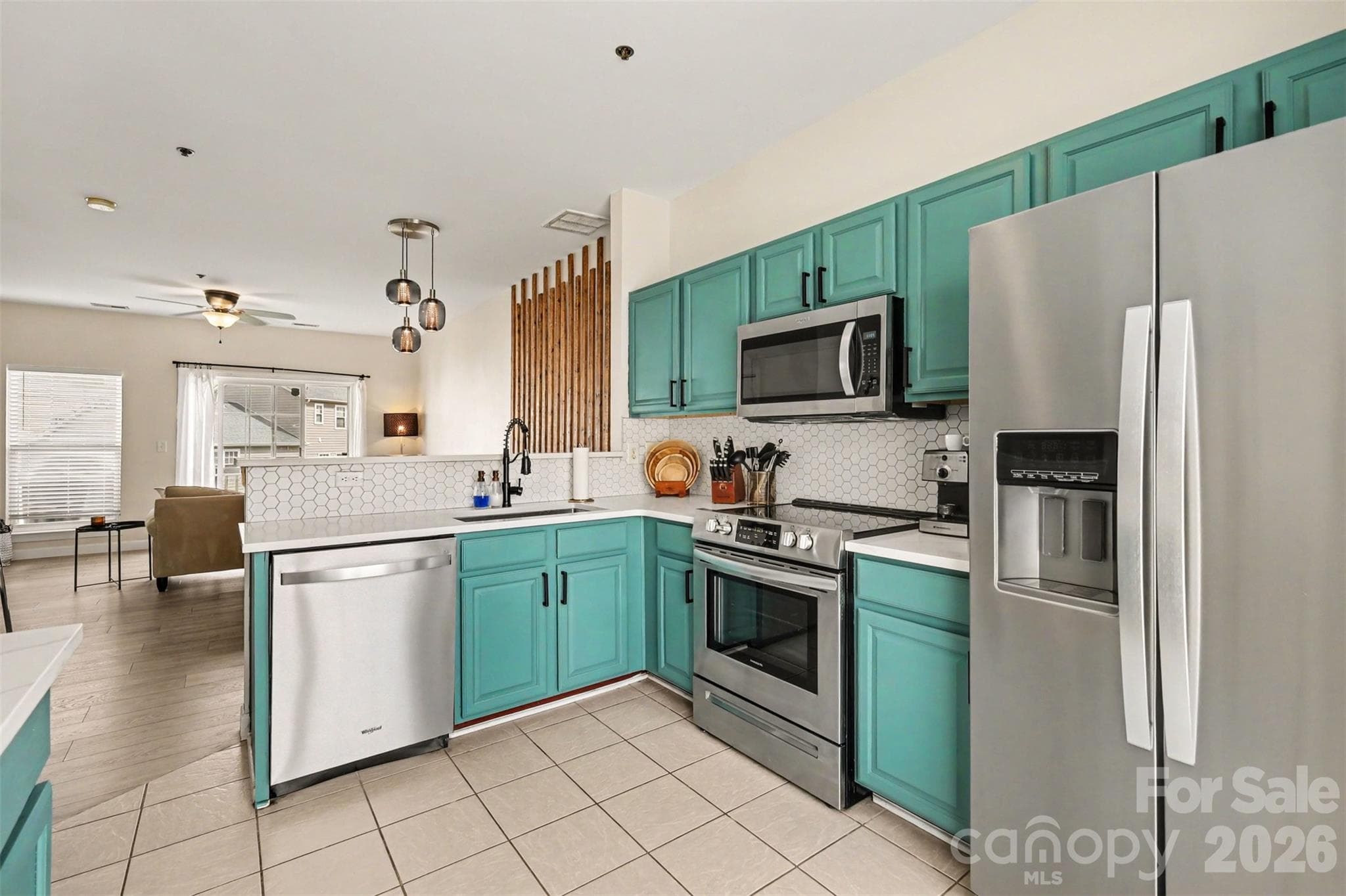 Updated kitchen featuring stainless steel appliances, modern cabinetry, hexagon tile backsplash, and additional built-in cabinetry for stylish storage and functionality. - 2729 Avalon Loop Road, Charlotte