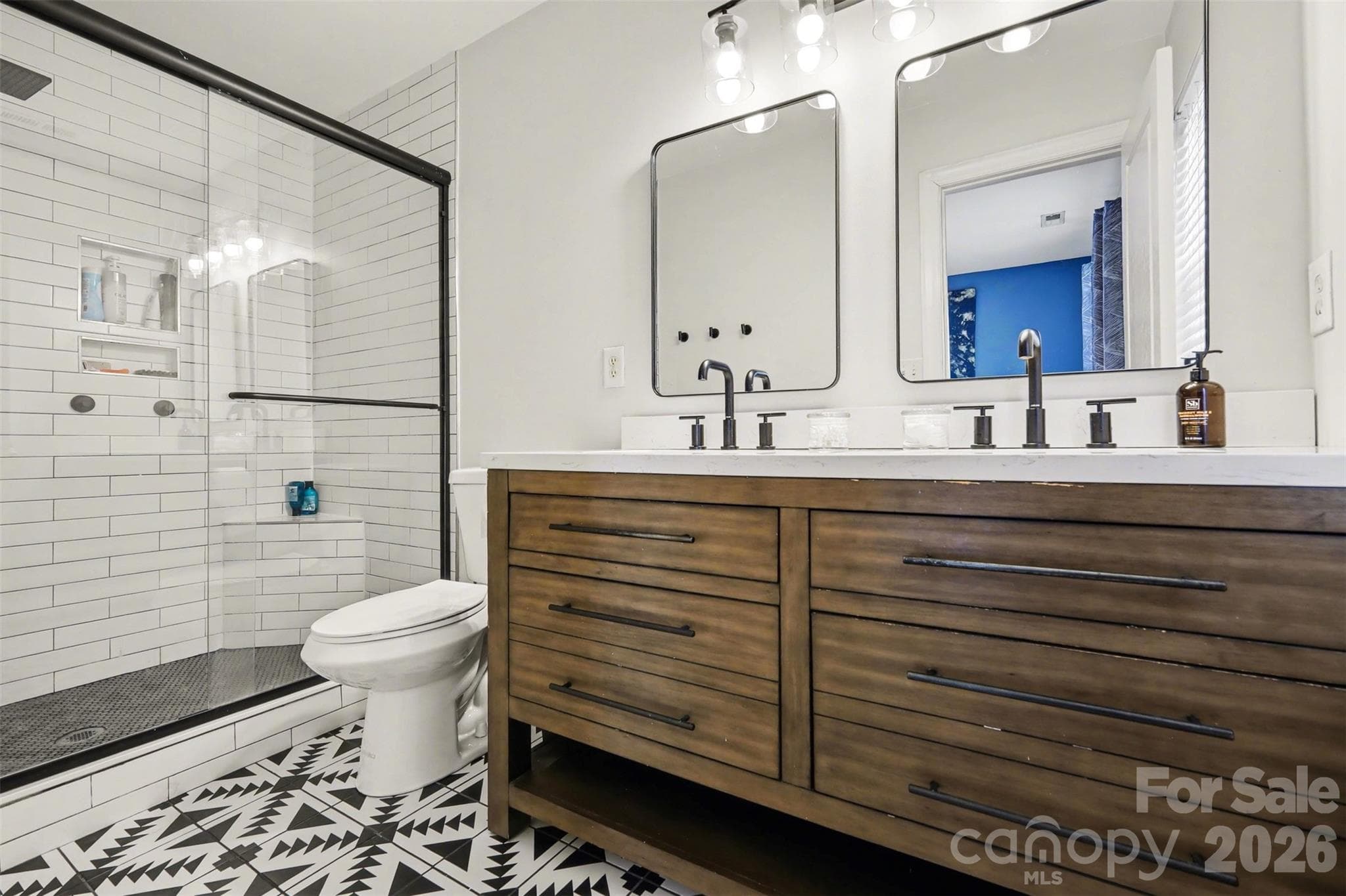 Fully renovated primary bathroom featuring timeless black-and-white finishes, modern fixtures, and a clean, contemporary design. - 2729 Avalon Loop Road, Charlotte