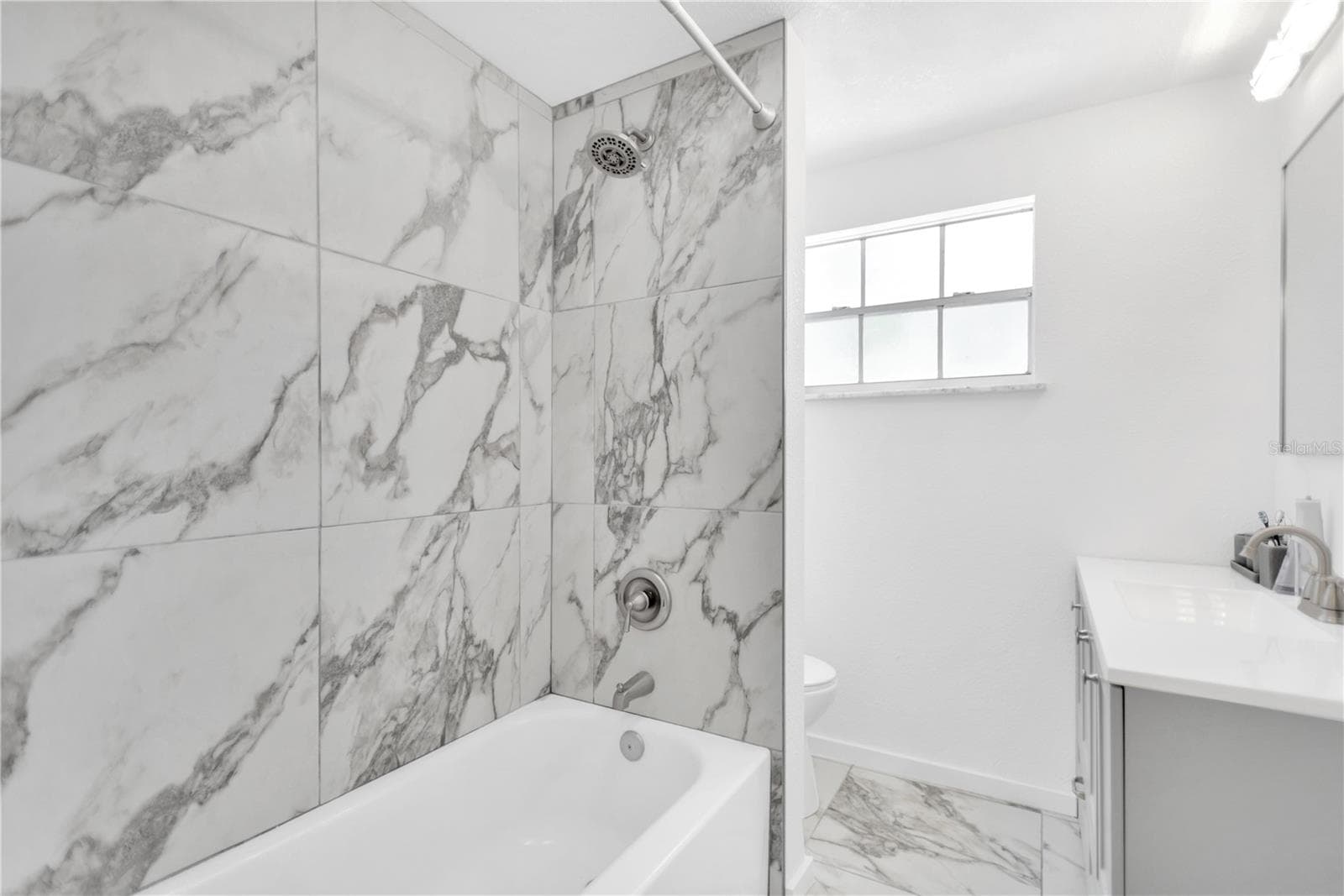 Guest bathroom offers shower with tub carrying the elegance of full tile forward. - 13724 COX AVE, HUDSON