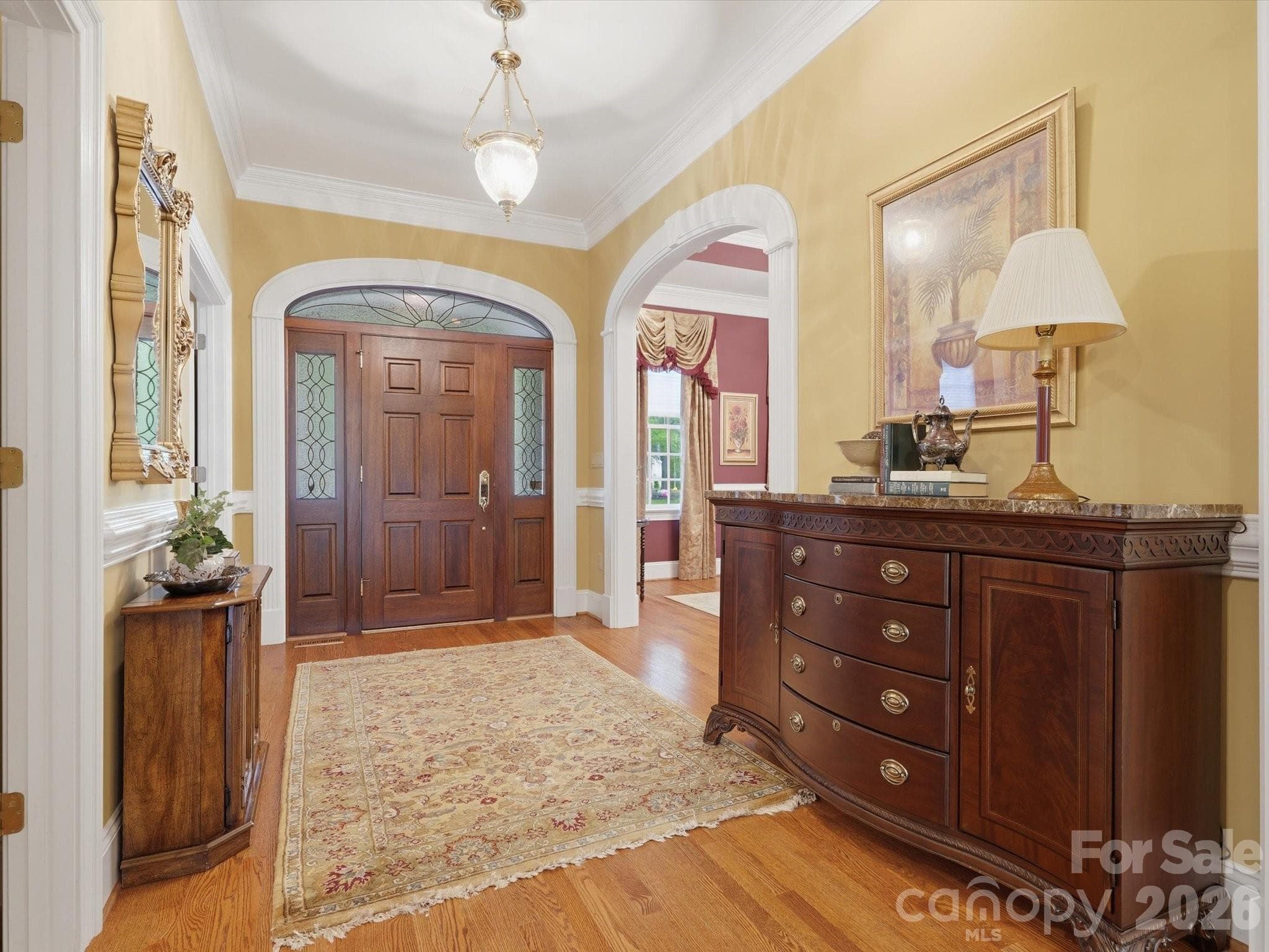 Foyer.   Extensive Millwork arched doorways with keystone inlay.  Dining room entrance/ office/bed entrance/ half bath entrance all in foyer area. - Monroe