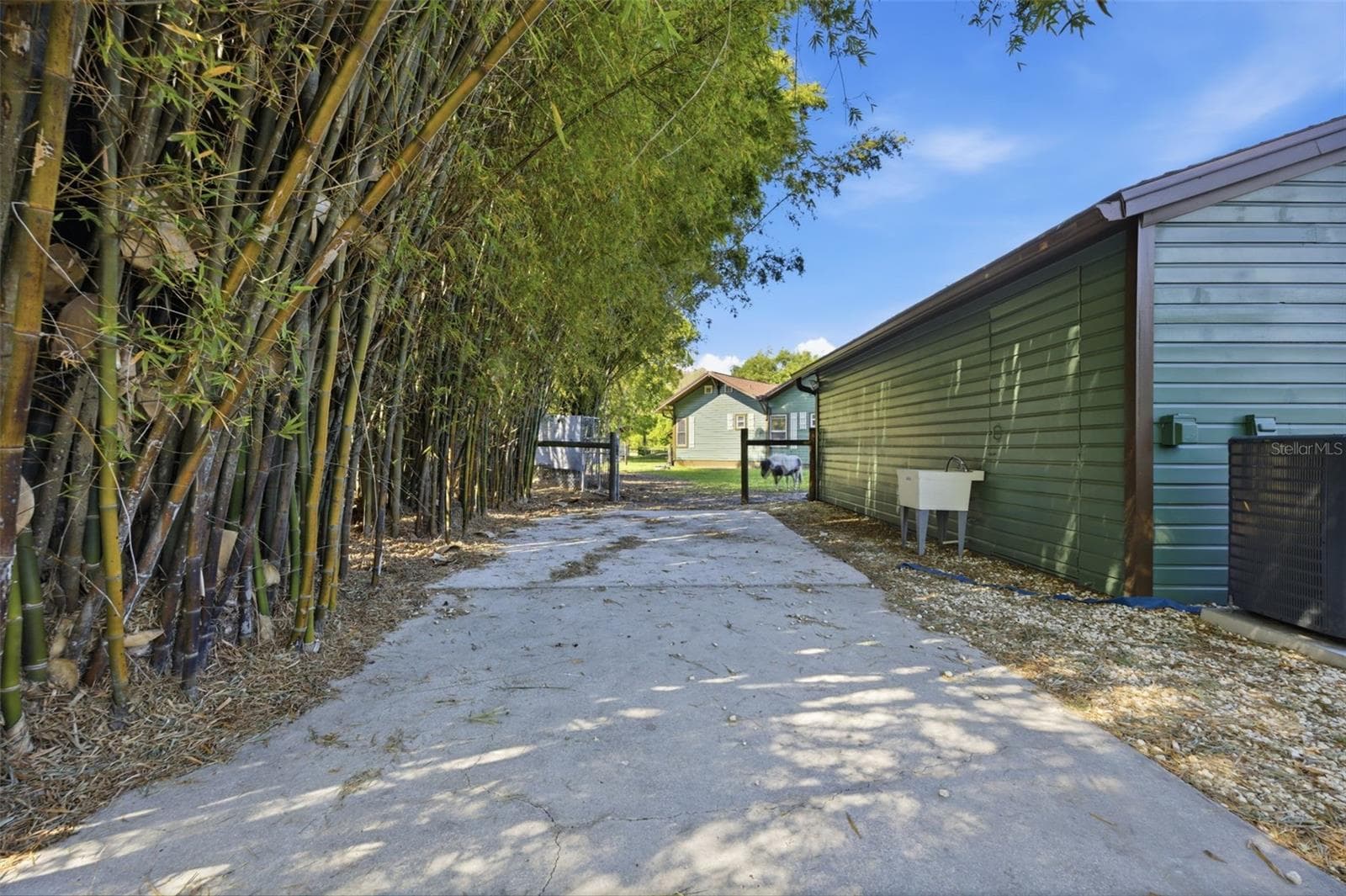 Parking pad, view of back of In-Law suite and gate to front yard - 3752 OLD KEYSTONE RD, TARPON SPRINGS