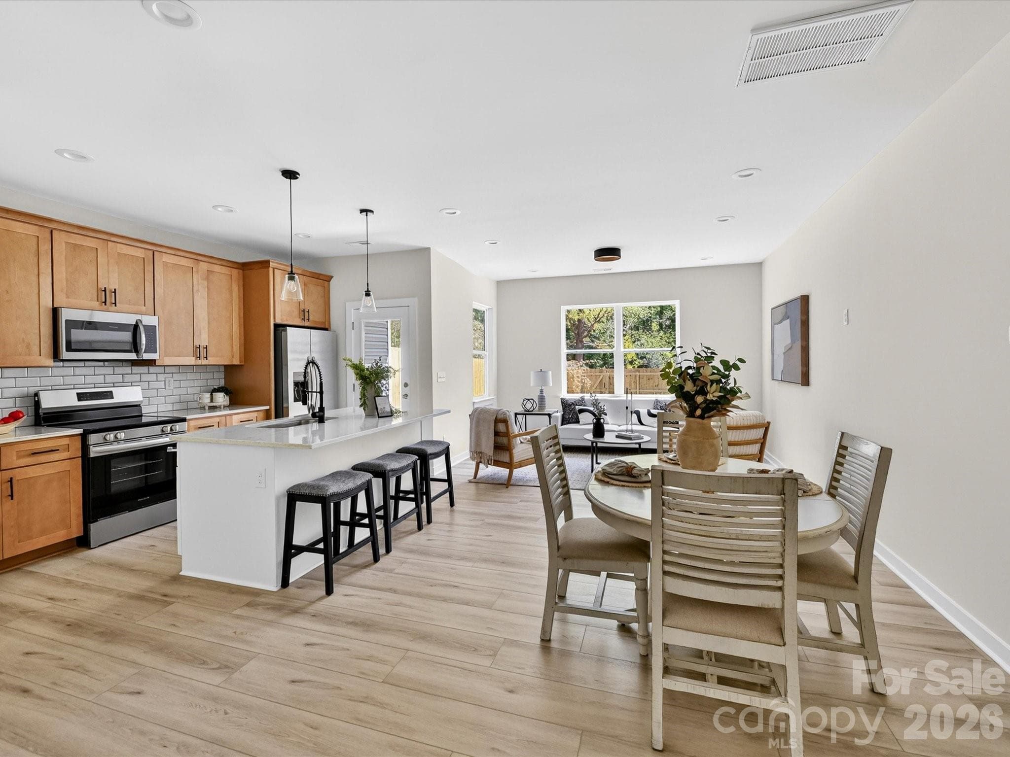 Open-concept kitchen flows seamlessly into a bright breakfast nook and living area, creating an inviting space ideal for both everyday dining and entertaining. - 655 Stillgreen Lane, Charlotte