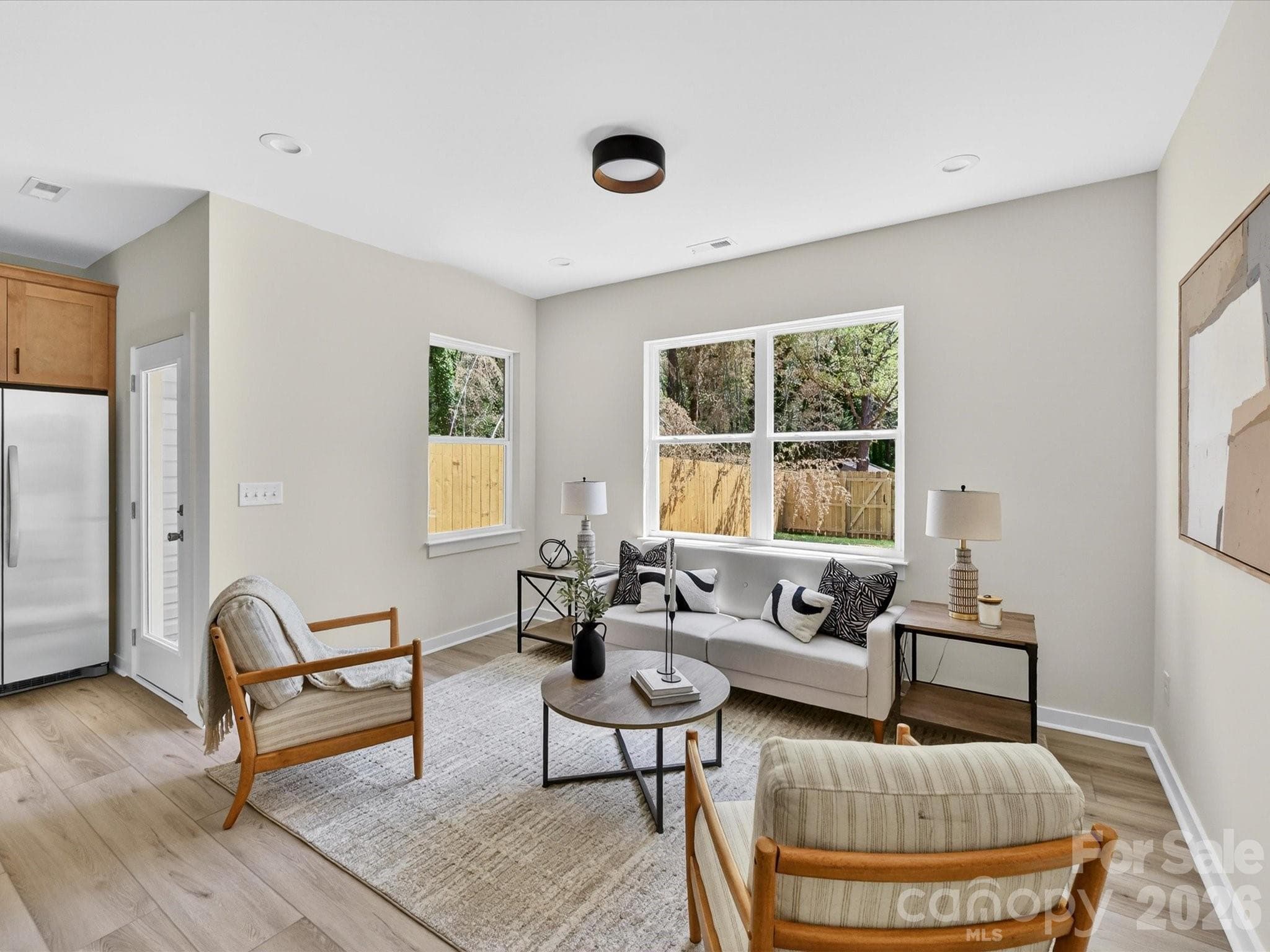 Bright and inviting family room filled with natural light, offering an open layout that seamlessly connects to the kitchen and dining area for comfortable everyday living. - 655 Stillgreen Lane, Charlotte