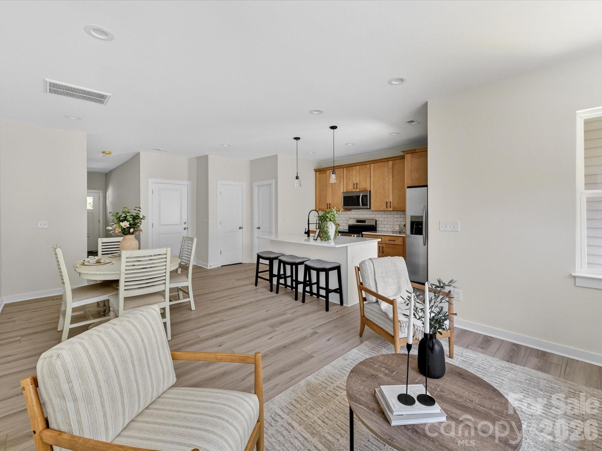Bright and inviting family room filled with natural light, offering an open layout that seamlessly connects to the kitchen and dining area for comfortable everyday living. - 655 Stillgreen Lane, Charlotte