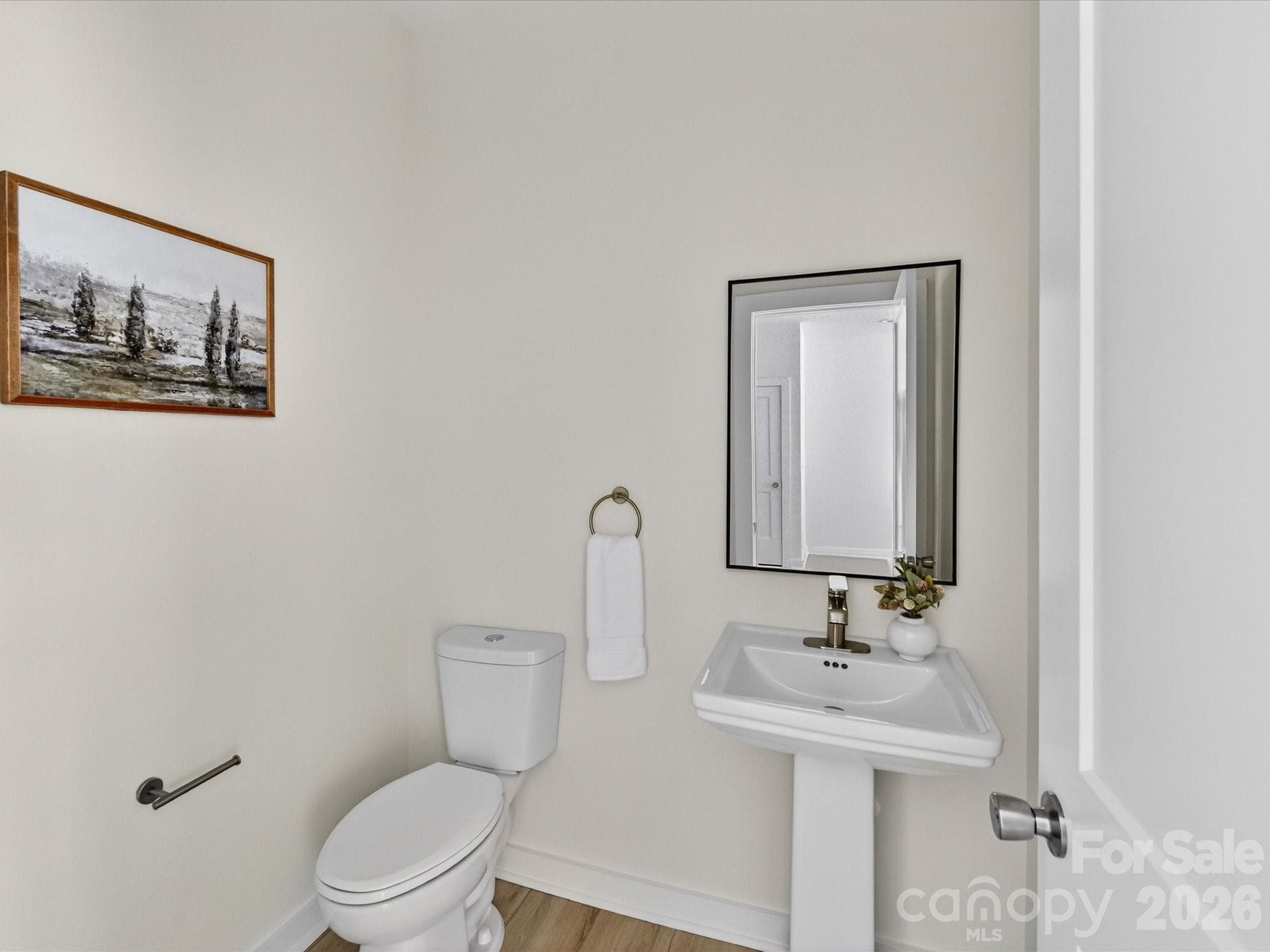 Convenient main-level powder room featuring a pedestal sink, clean finishes, and a bright, modern design. - 655 Stillgreen Lane, Charlotte