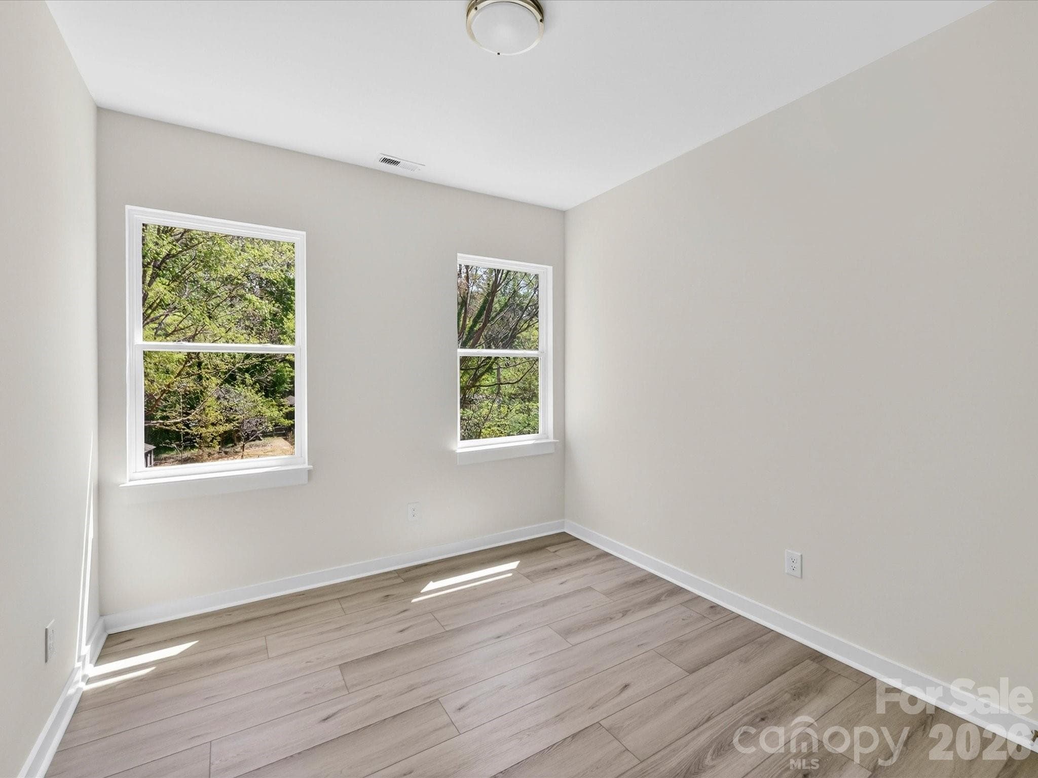 Bright secondary bedroom featuring abundant natural light, neutral finishes, and a versatile layout perfect for guests, family, or a home office. - 655 Stillgreen Lane, Charlotte