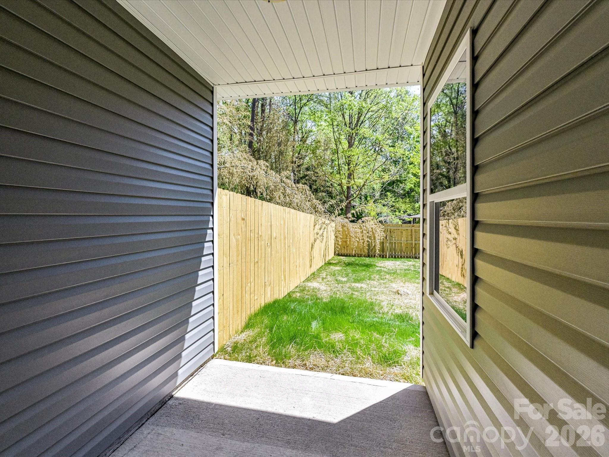 Covered patio offering a private outdoor retreat with easy access to a fenced backyard, perfect for relaxing or entertaining. - 655 Stillgreen Lane, Charlotte