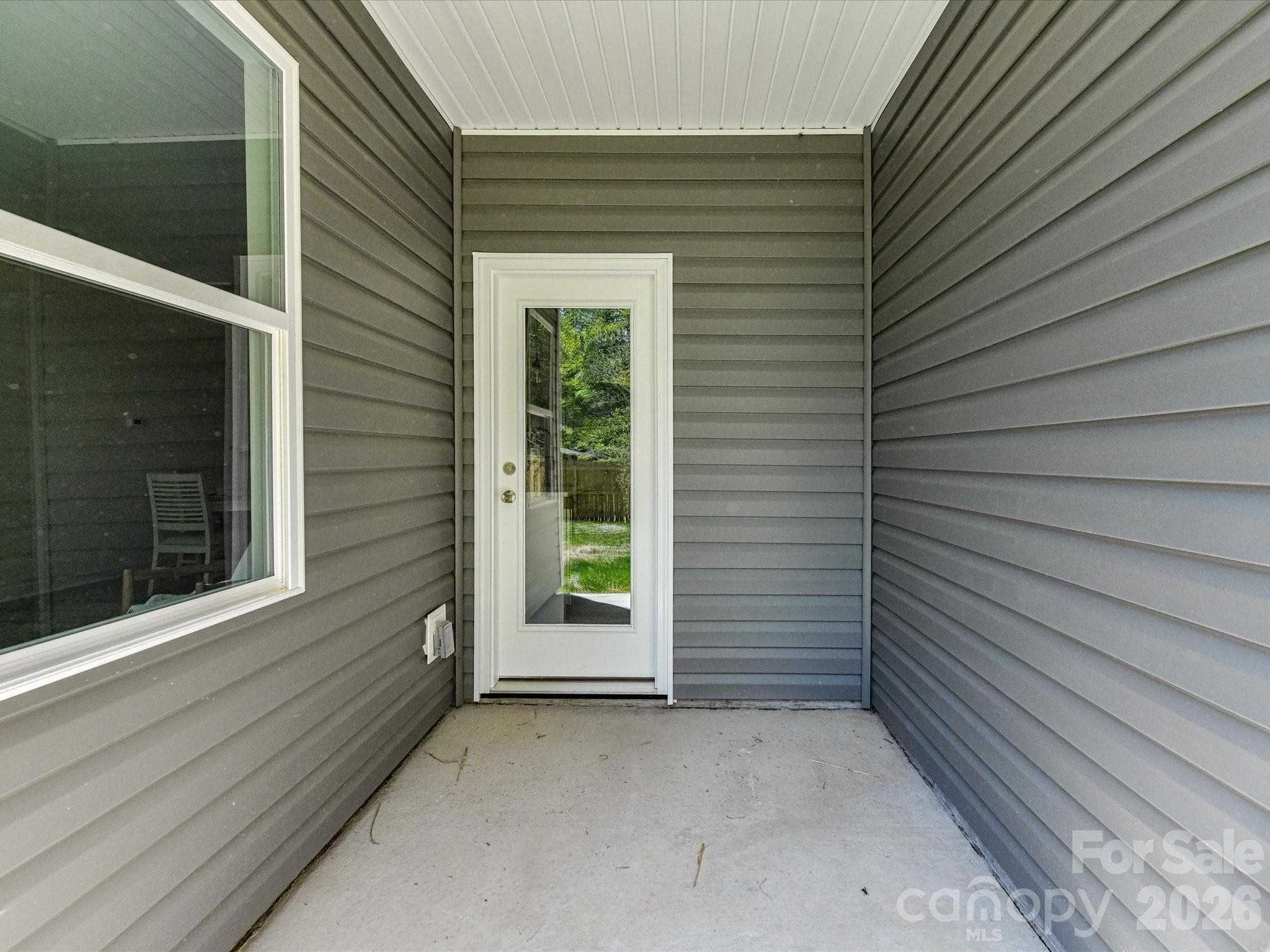 Covered patio offering a private outdoor retreat with easy access to a fenced backyard, perfect for relaxing or entertaining. - 655 Stillgreen Lane, Charlotte
