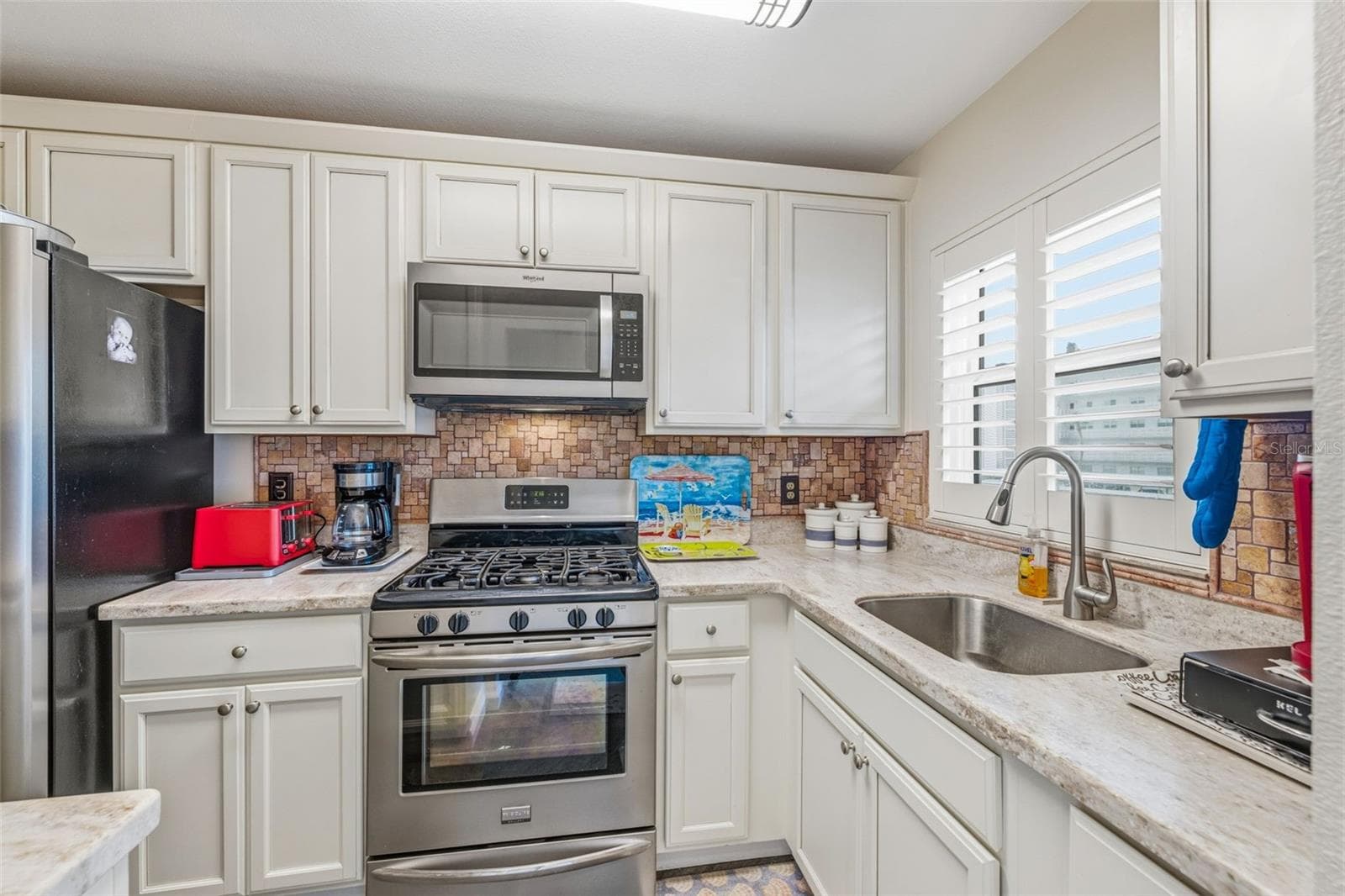 Updated kitchen with white cabinetry - 5521 80TH ST N #212, ST PETERSBURG
