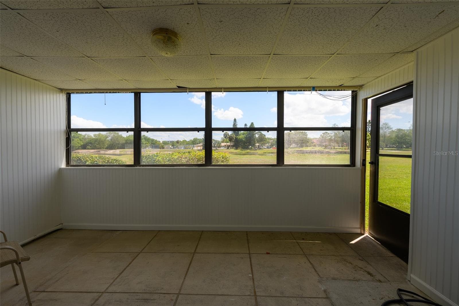 Enclosed porc with back door to green space/pond. - 1308 13TH CIR SE, LARGO