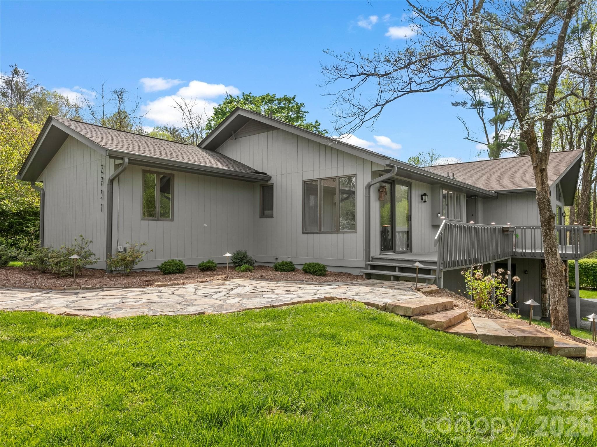 Beautiful stone steps lead from the lower-level garage to the main living level, adding charm and character to the home's design. - 2731 Miller Lane, Hendersonville