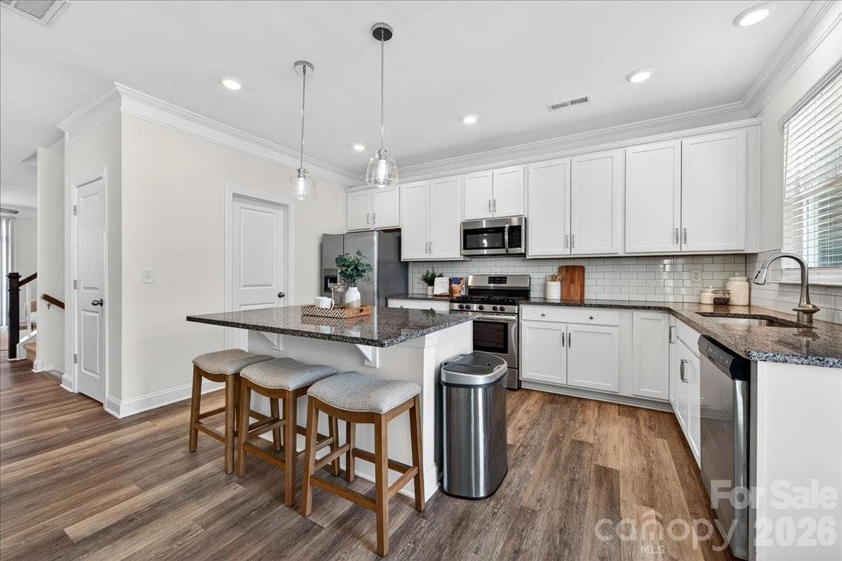 Light airy kitchen notice the canned and pendant lighting. - 10436 Glenmere Creek Circle, Charlotte