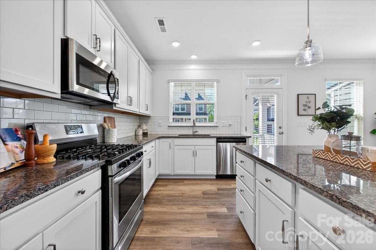 Spacious kitchen with large island and white cabinets with a 5 burner gas stove!!! - 10436 Glenmere Creek Circle, Charlotte