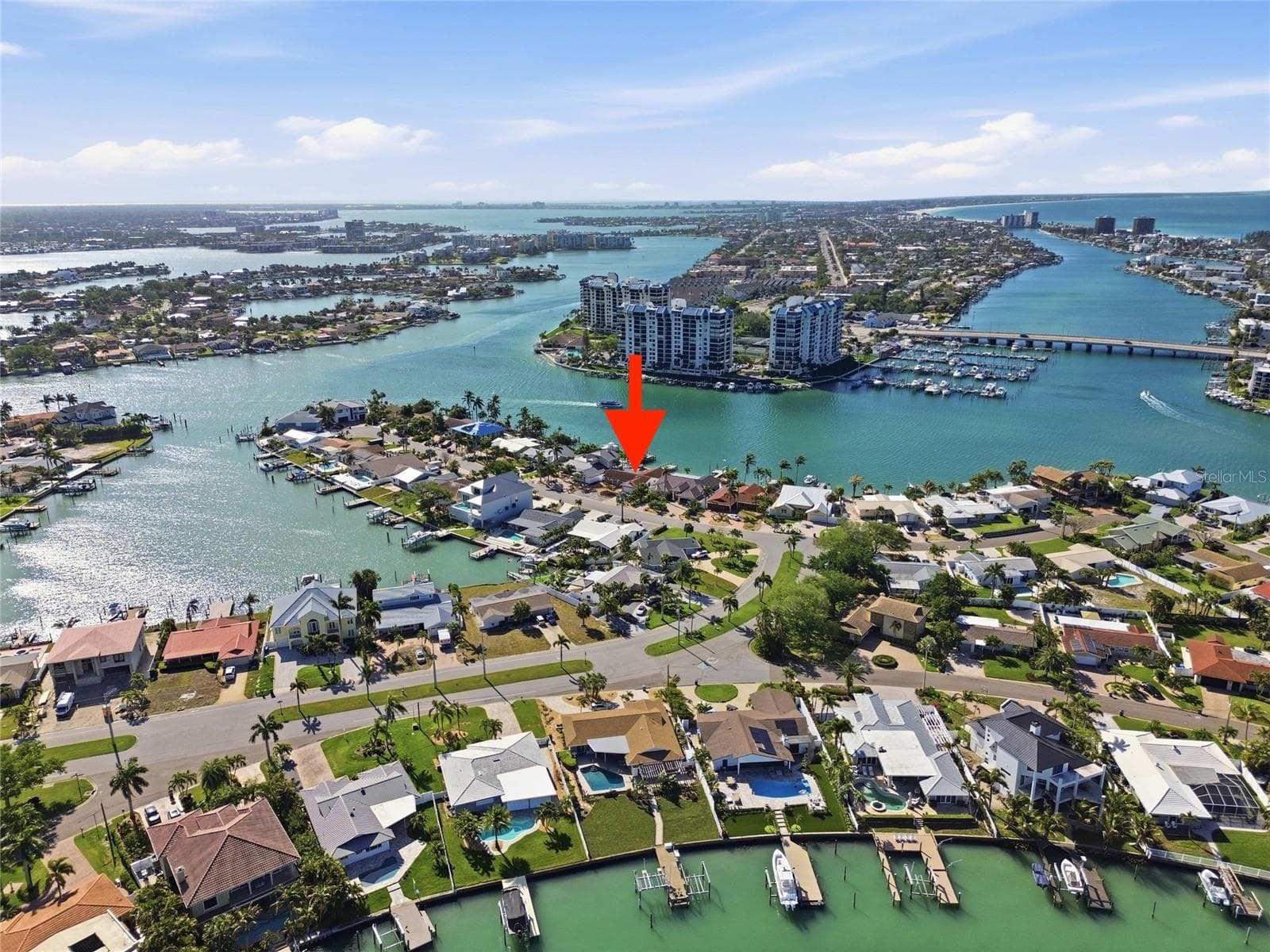 Drone photo of the broader Paradise Island neighborhood showing the Intracostal and the Gulf of Mexico to the right ("red arrow" indicates 4 Bellevue) and the continuation of the Intracoastal on the left. - 4 BELLEVUE DR, TREASURE ISLAND