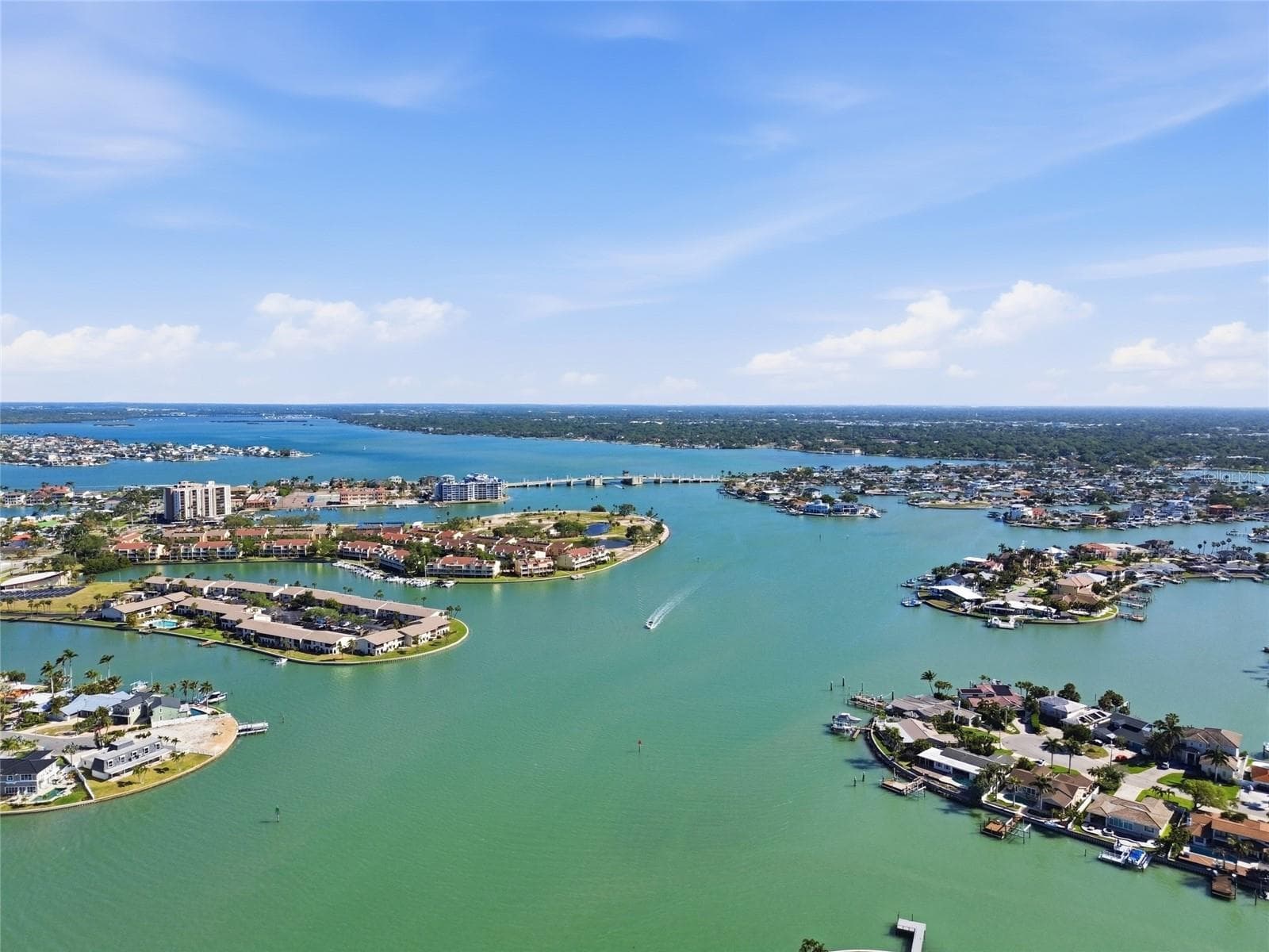 Aerial photo high above 4 Bellevue looking northwest towards Treasure Island Causeway drawbridge allowing access to the Gulf for larger sailboats and motorboats. - 4 BELLEVUE DR, TREASURE ISLAND