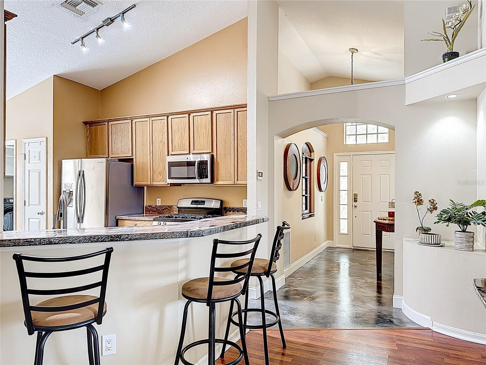 Additional view of the kitchen showcasing the functional layout and breakfast bar seating. - 7116 COLONY POINTE DR, RIVERVIEW