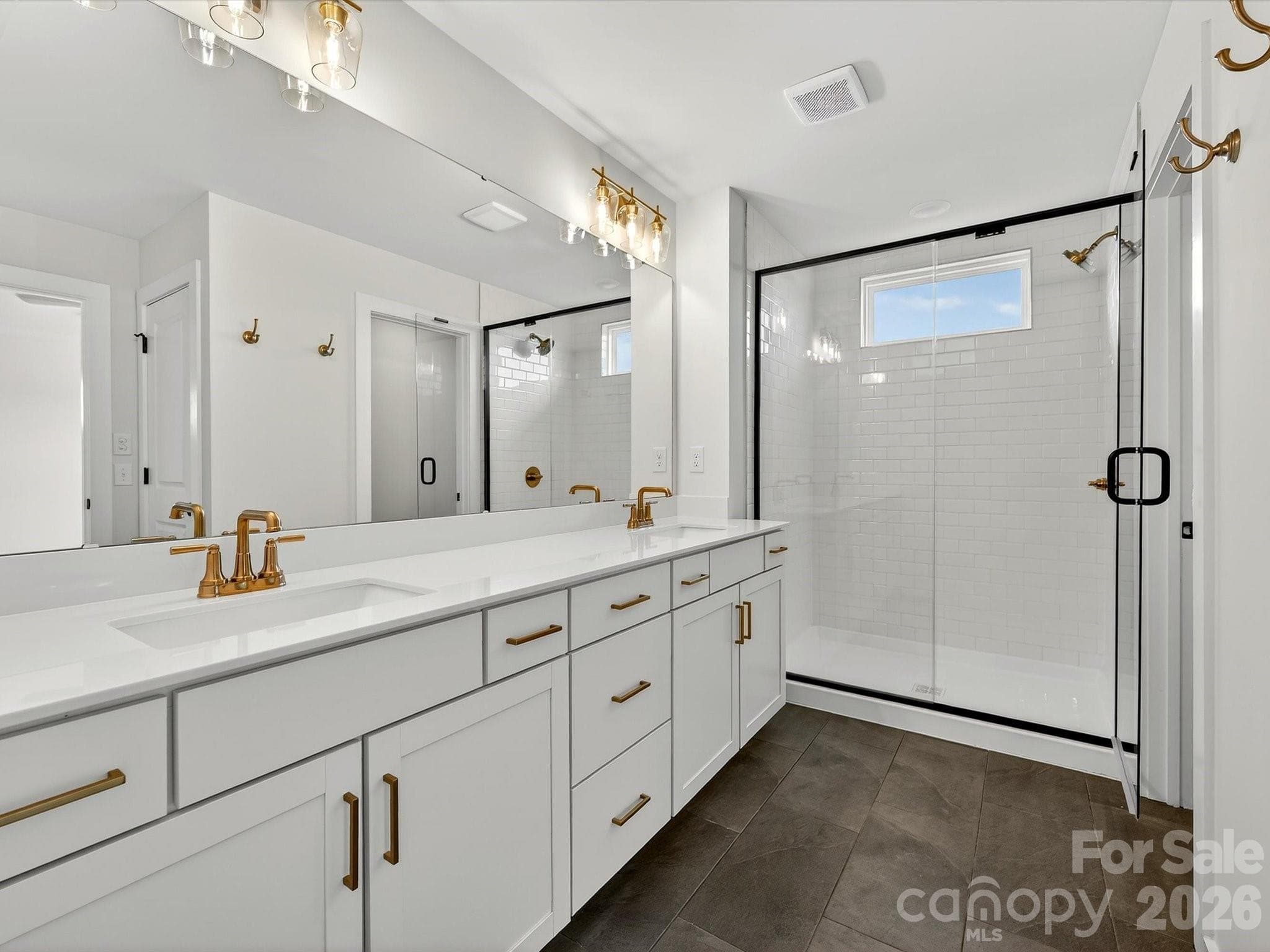 Primary bath with large, tiled shower, large dual vanity with quartz countertops. Tiled floor. Separate toilet in closet - 202 Quartz Hill Way, Waxhaw