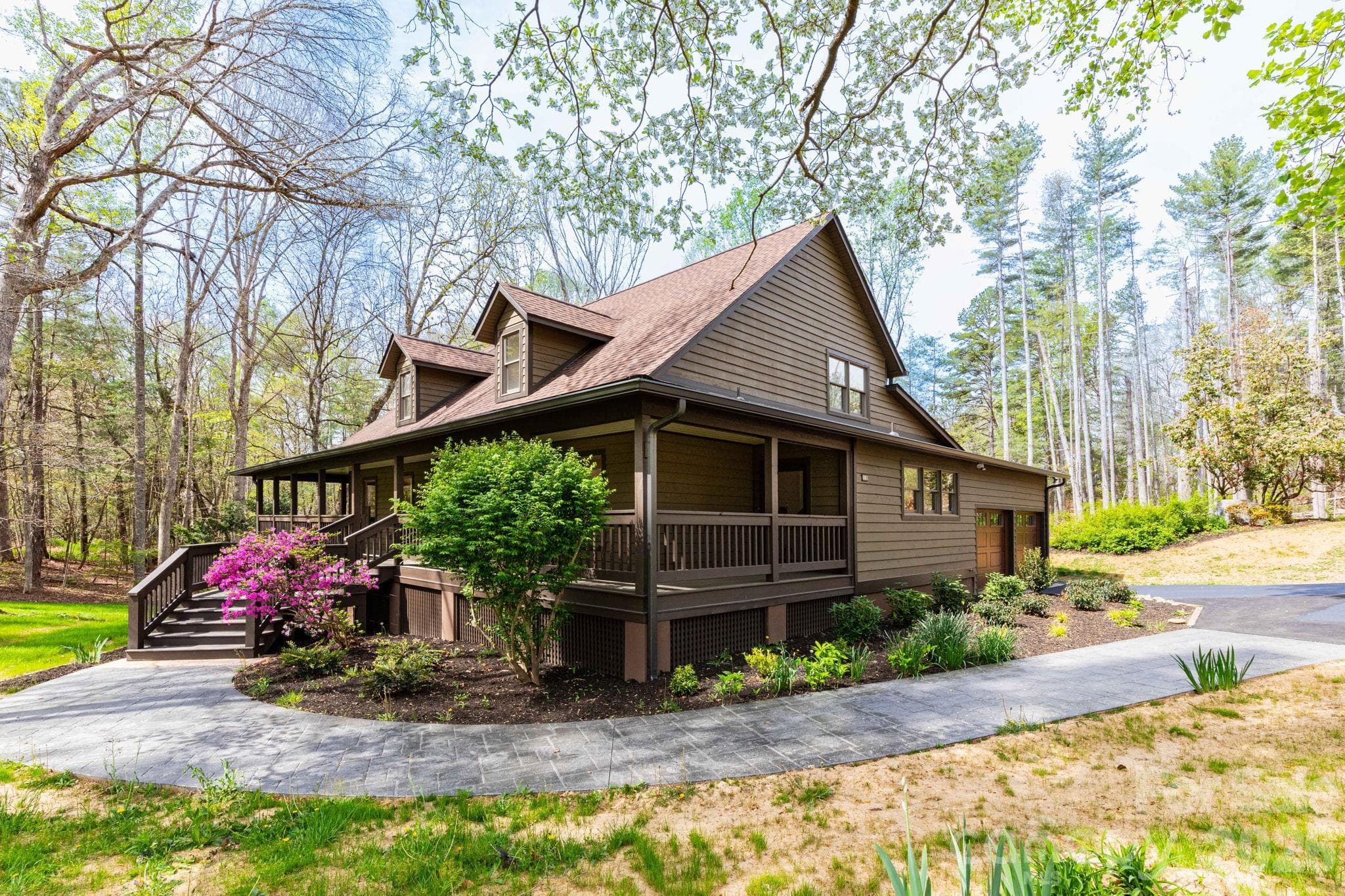 Side view showcasing the home's natural setting and well-maintained landscaping, blending seamlessly into the surrounding woods. - Fletcher