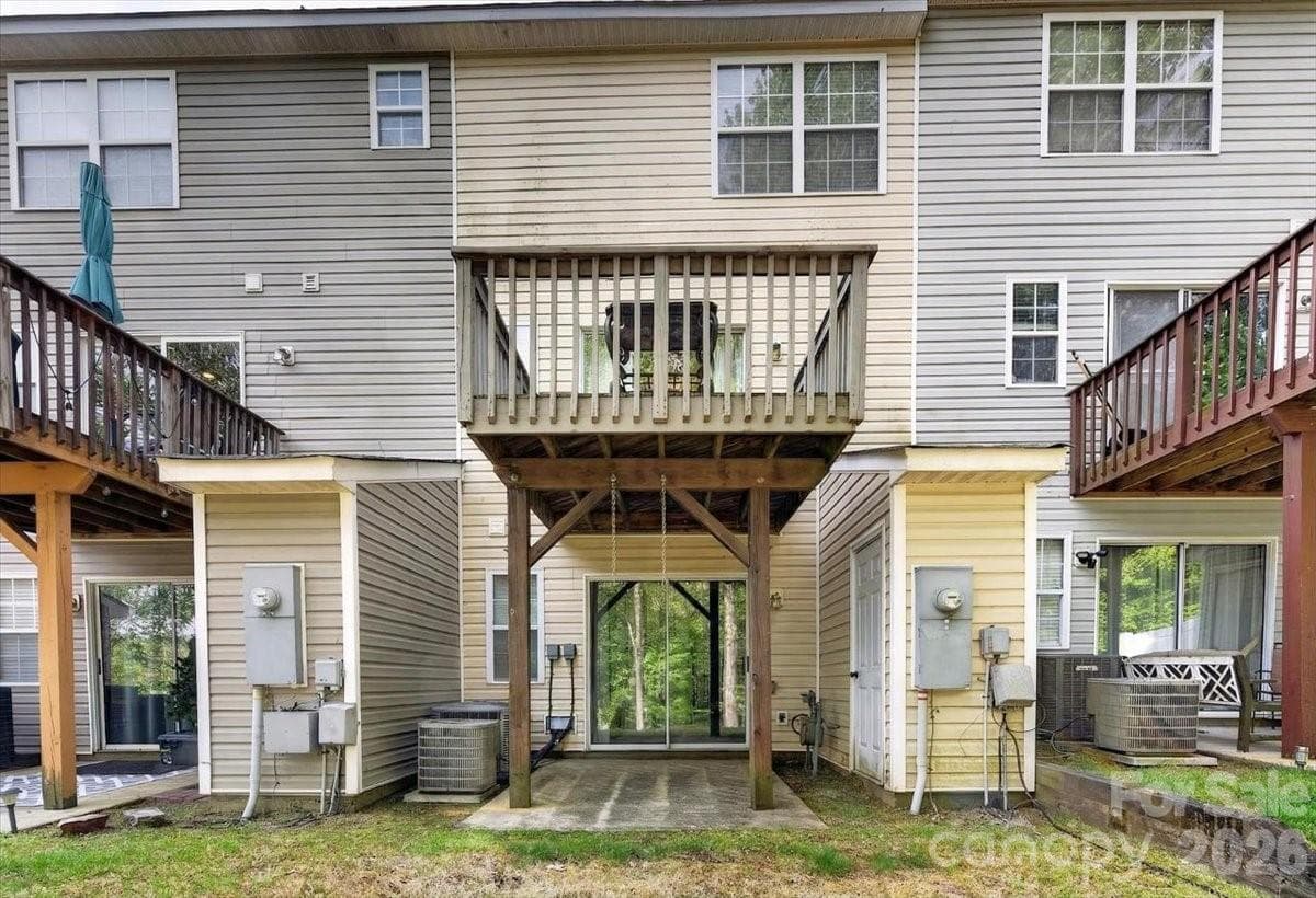 An upper deck and the patio overlook a private backyard with a view of a pond and fountain - Charlotte