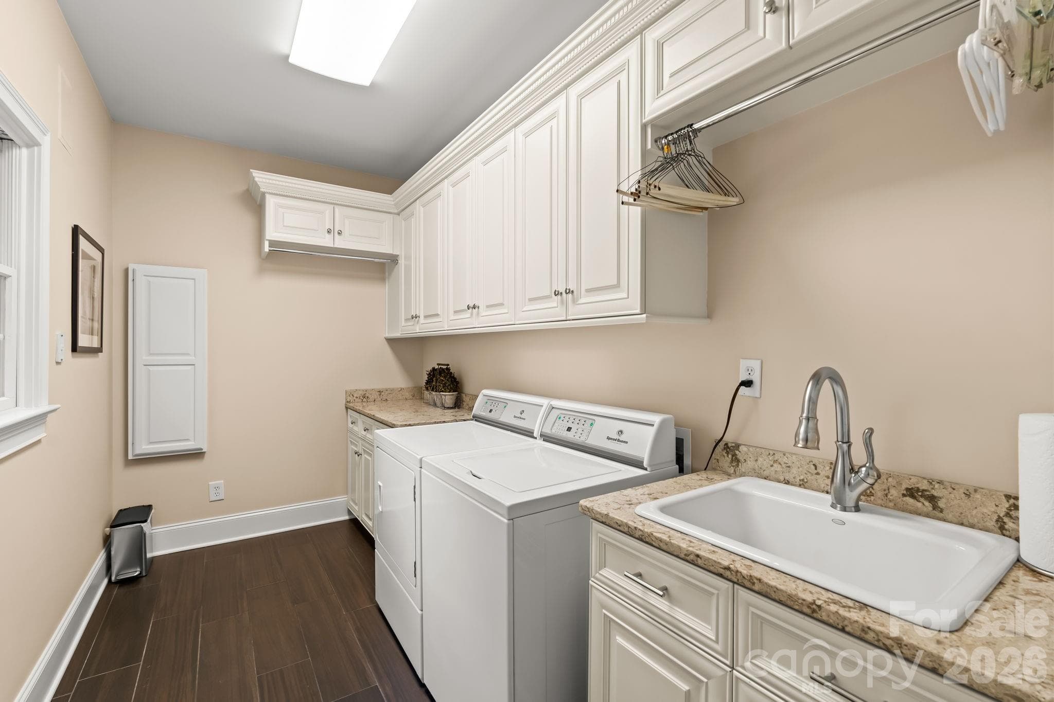 Main level laundry room with wash sink and storage - Lewisville