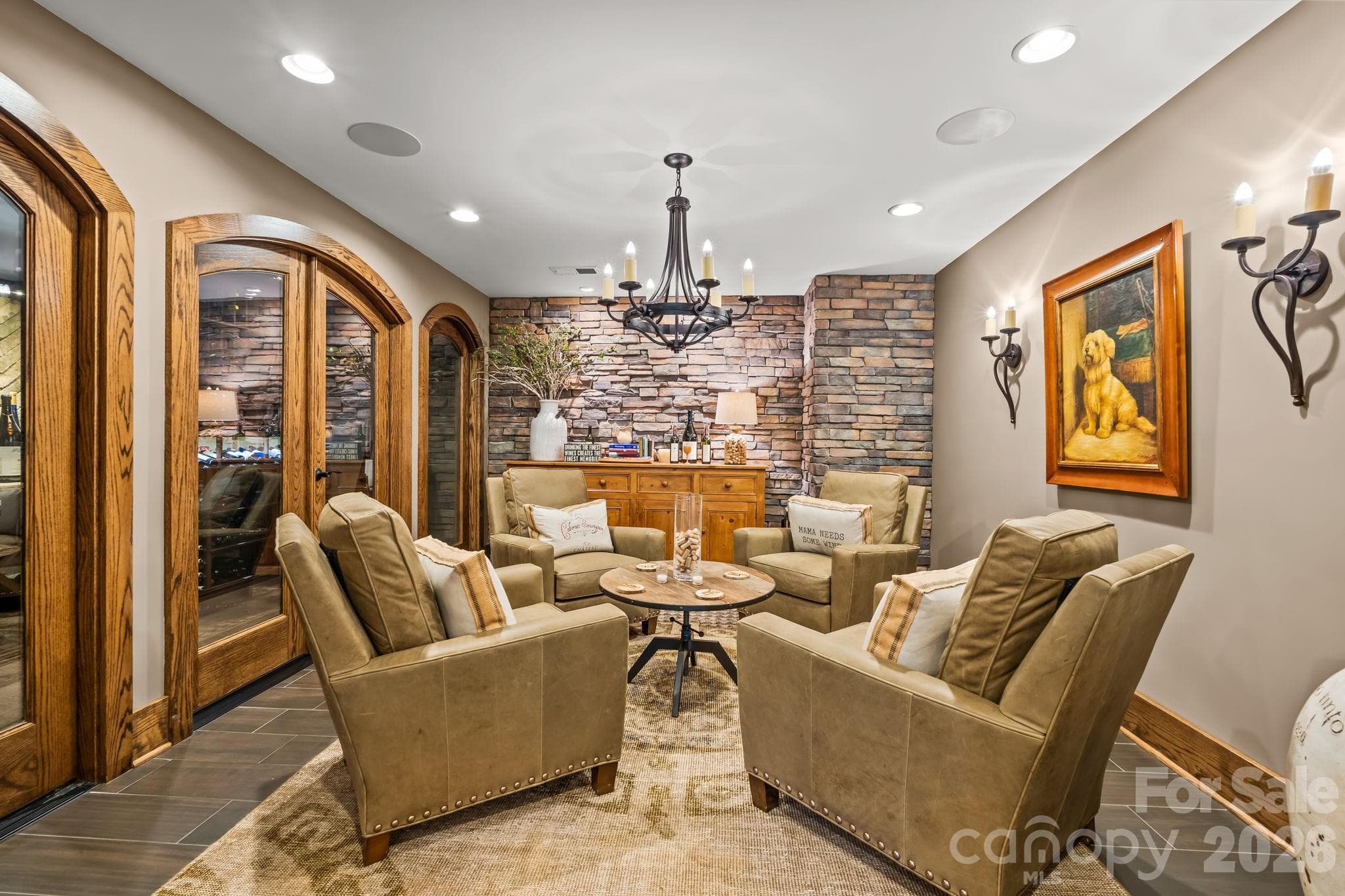 The tasting room with stone clad wall, wood trim, chandelier, and front row seats to the wine cellar. - Lewisville
