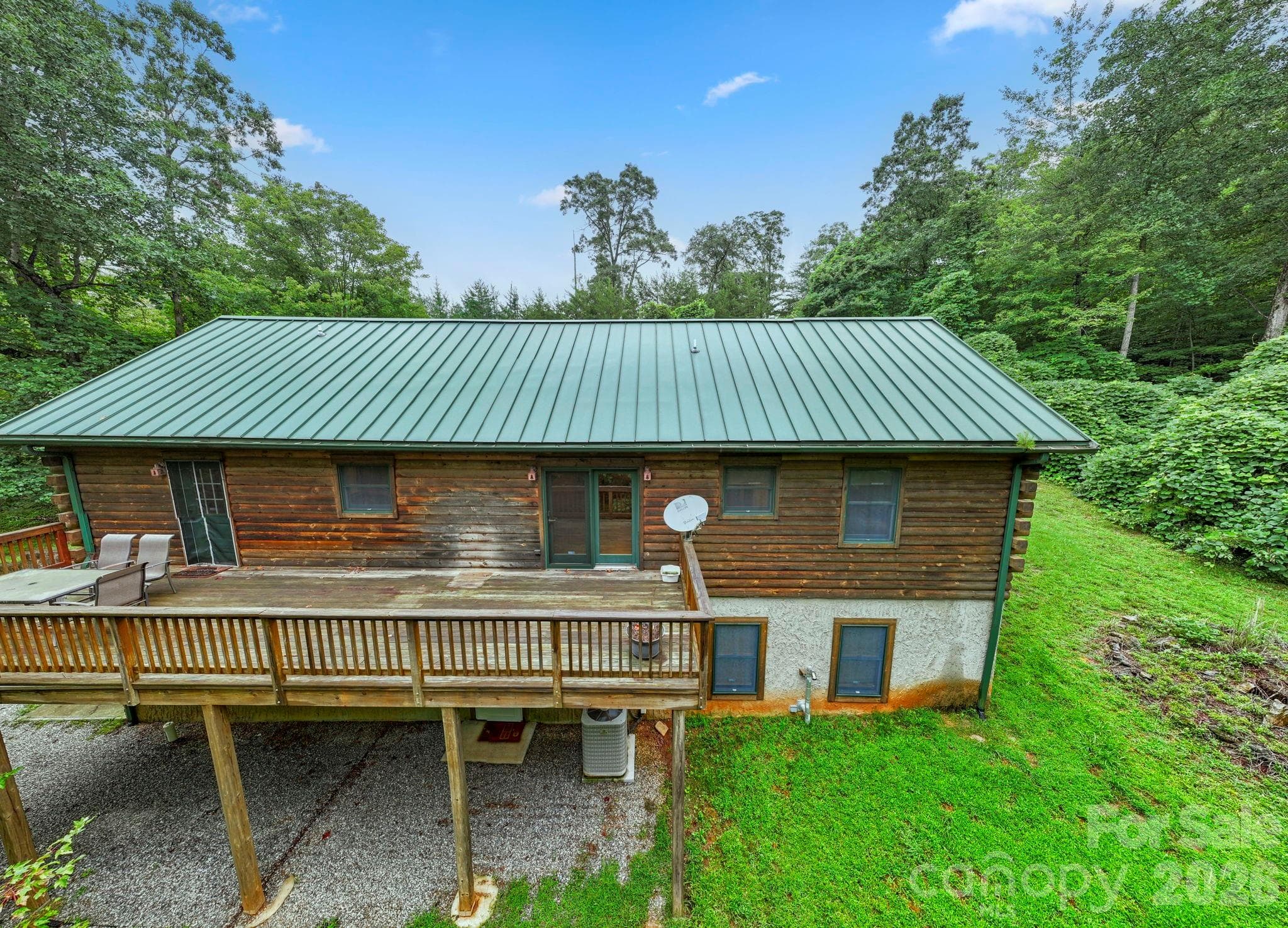 Rear exterior view highlighting the elevated deck and peaceful backyard setting. - 266 Rhododendron Drive, Saluda