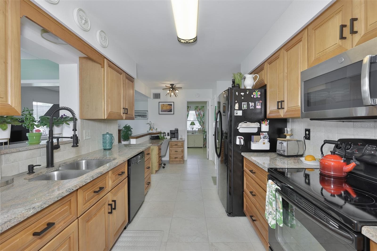 Galley Kitchen, Wood Cabinets, Granite Countertops, Built In Desk, Closet Pantry, Pass Through - 1704 DANBURY DR, SUN CITY CENTER
