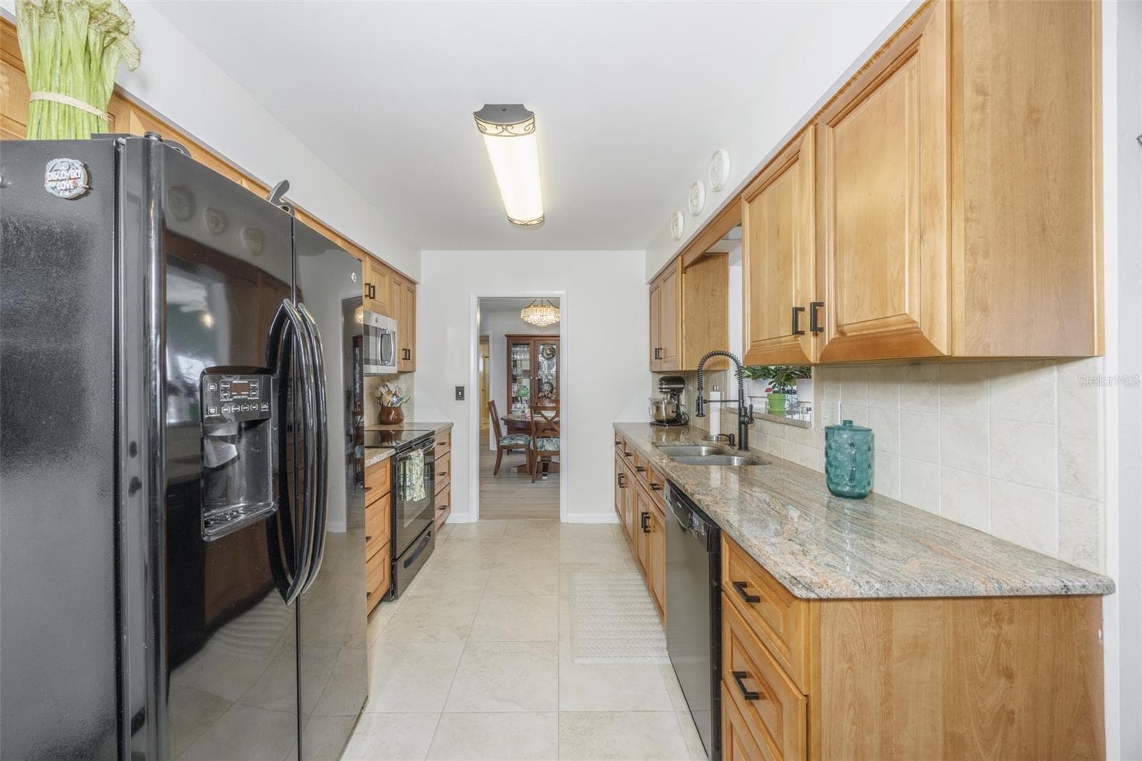 Galley Kitchen, Wood Cabinets, Granite Countertops, Pass Through to Enclosed Lanai - 1704 DANBURY DR, SUN CITY CENTER