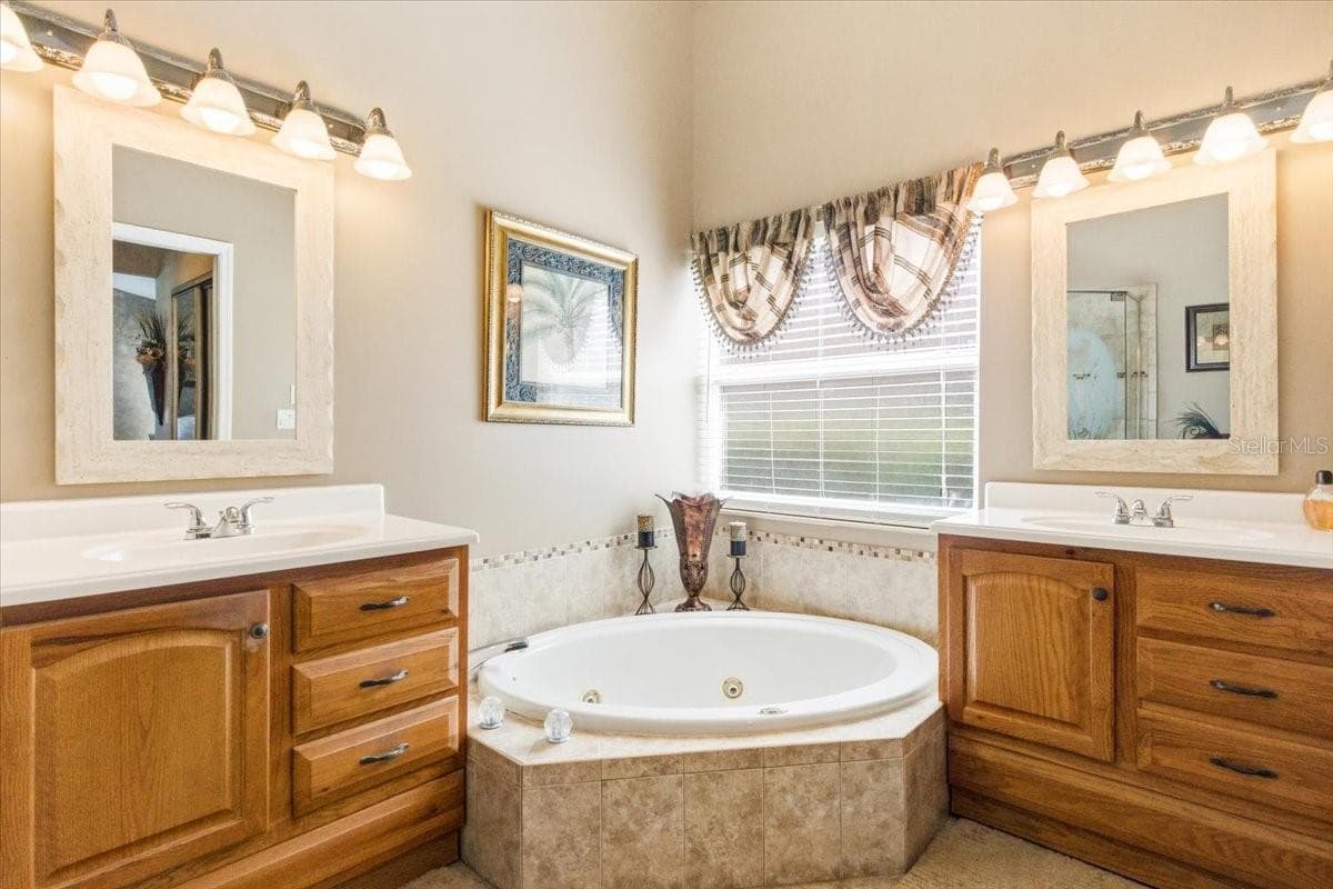 Primary bath features whirlpool garden tub and split vanities - 7015 PLEASANT HILL RD, BRADENTON