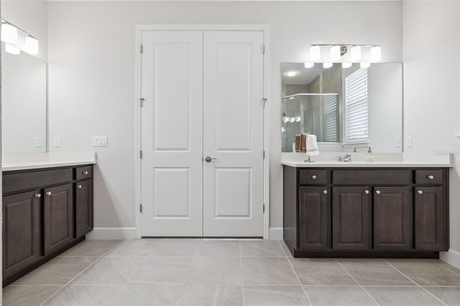 Primary bath with two vanities. Double doors lead to the primary bedroom - 1157 AVERY MEADOWS WAY, DELAND