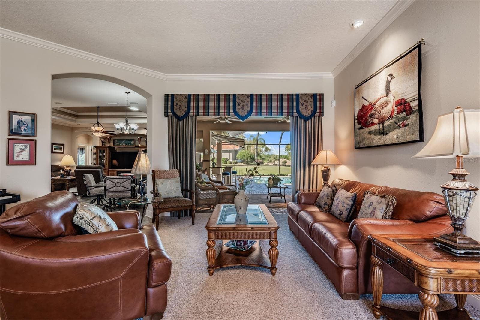 Living room with sliders to pool deck and lanai - 34115 AMERICANA AVE, DADE CITY