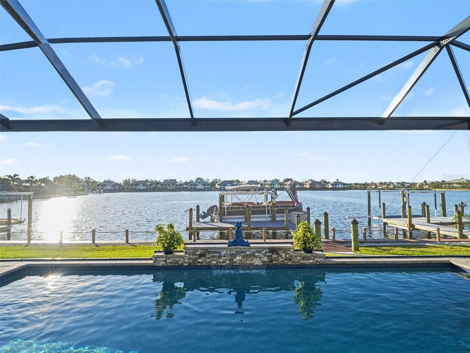 Screened waterfront lanai with panoramic water views, ideal for outdoor dining, entertaining, and enjoying the coastal lifestyle. - 1018 OVERLOOK CT, BRADENTON