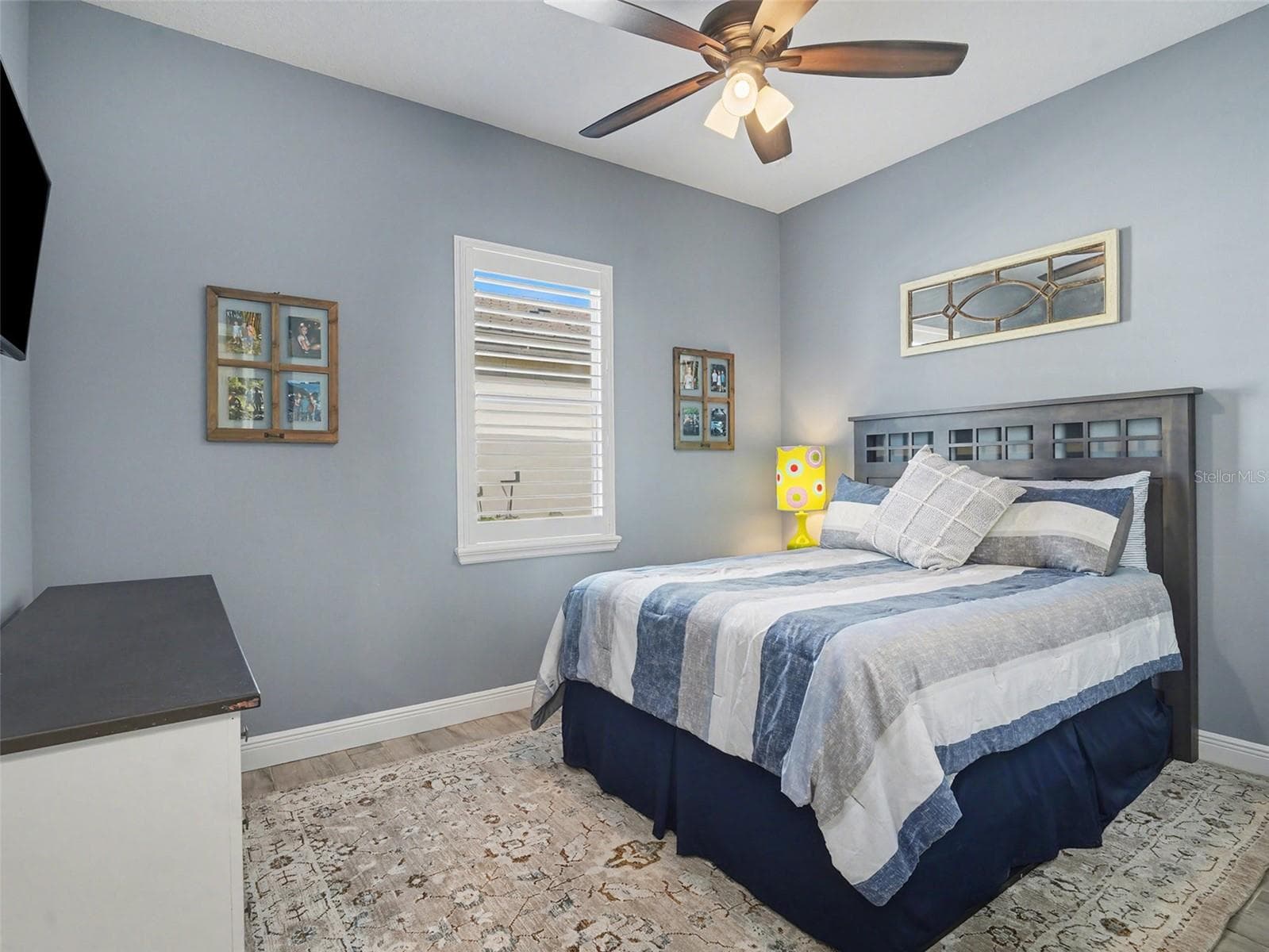 Bright guest bedroom with ceiling fan, soft natural light, and a comfortable layout for family or overnight visitors. - 1018 OVERLOOK CT, BRADENTON