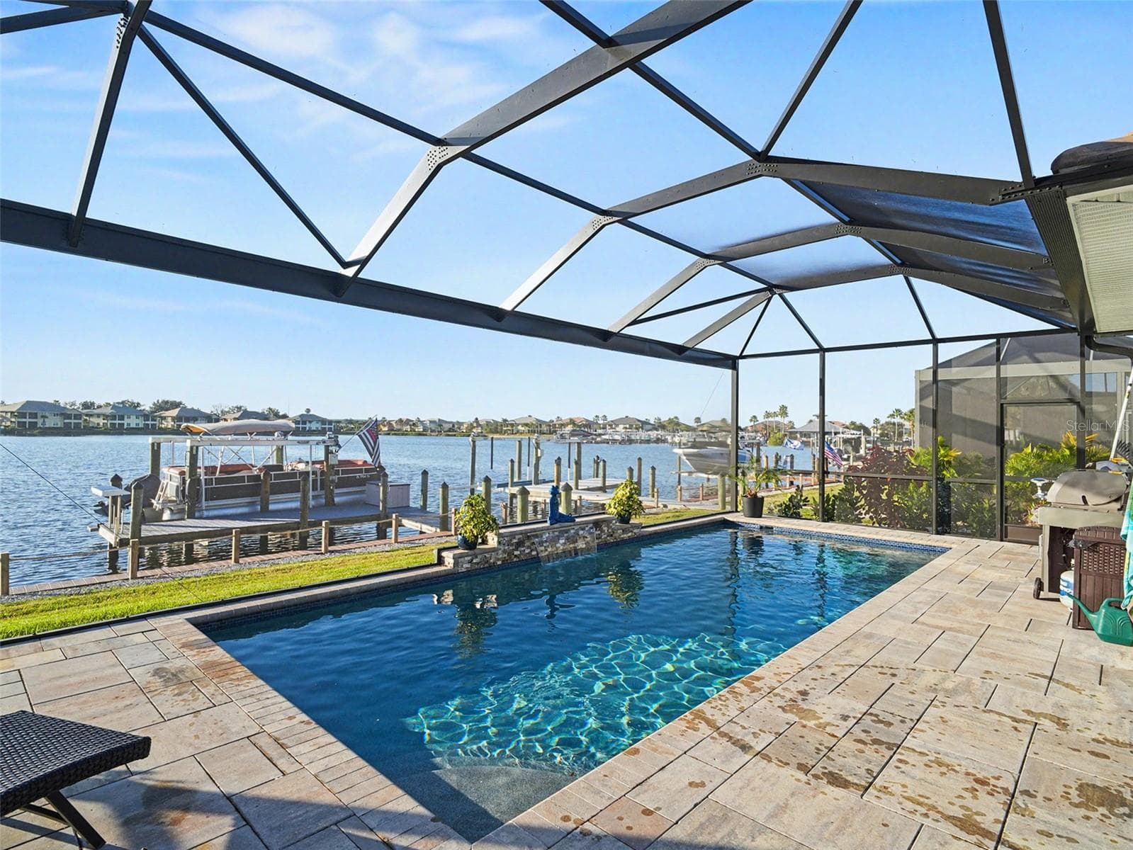 Screened pool deck with sparkling water views, expansive entertaining space, and a true resort style setting. - 1018 OVERLOOK CT, BRADENTON