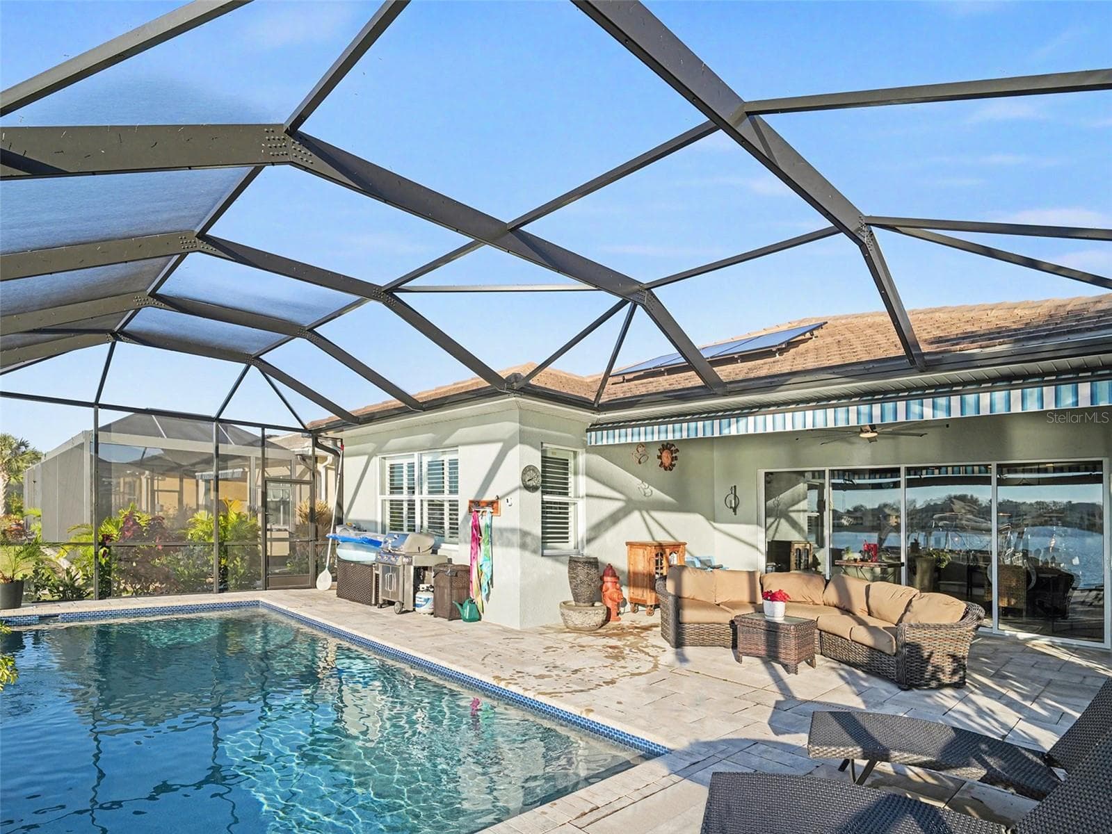 Resort style pool area under screen enclosure with generous deck space for lounging, dining, and enjoying the waterfront backdrop. - 1018 OVERLOOK CT, BRADENTON